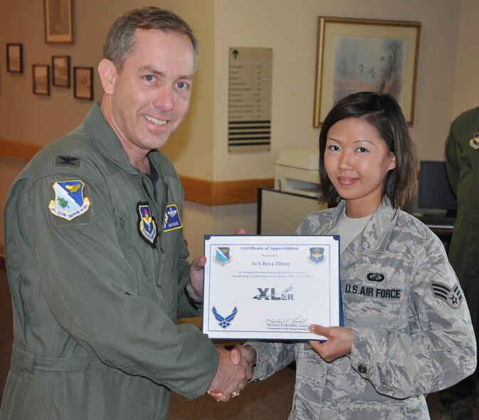 LAUGHLIN AIR FORCE BASE, Texas –Senior Airman Jenny Zheng, 47th Comptroller Squadron, is presented the XLer of the Week award by Col. Michael Frankel, 47th Flying Training Wing commander, July 7. The XLer is a weekly award chosen by 47th FTW leadership and given to individuals who consistently make outstanding contributions to Laughlin and their unit. (U.S. Air Force photo by Airman 1st Class Blake Mize)