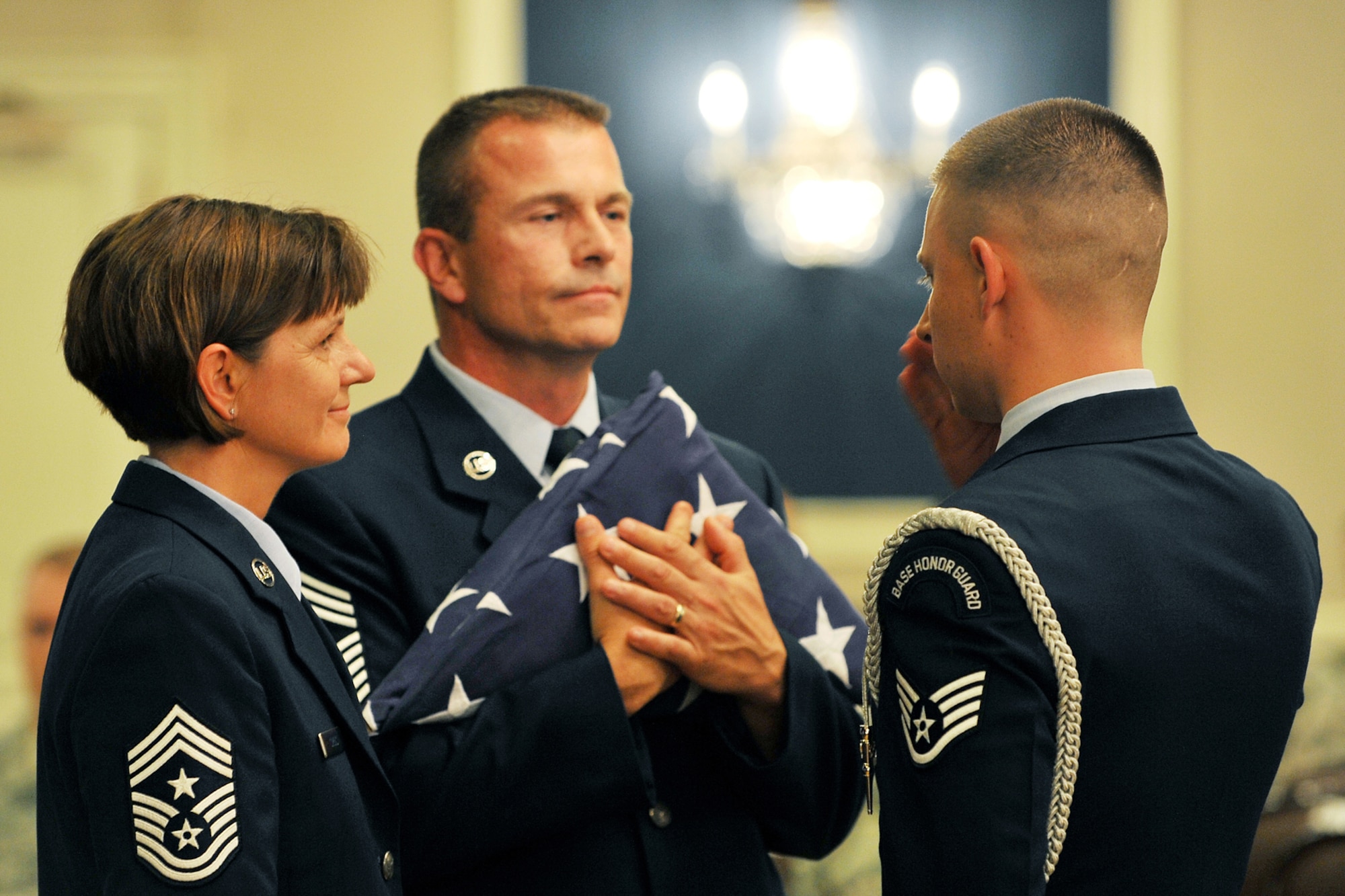 OFFUTT AIR FORCE BASE, Neb. - Staff Sgt. Aaron Molchak, NCO in charge of the Offutt honor guard detail, presents Chief Master Sgts. Lisa and Roger Sirois with a folded American flag during their dual retirement ceremony at the Patriot Club July 6. Chiefs Lisa and Roger Sirois are celebrating a combined 60 years of service to the United States Air Force. 

U.S. Air Force photo by Charles Haymond