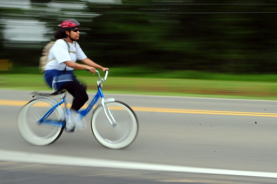 BARKSDALE AIR FORCE BASE, La. – A participant in the 2d Bomb Wing Sports Day bicycle race rides her bike on the East Reservation July 1. This year the event was changed to accommodate ‘skinny tire’ and ‘fat tire’ bikes – skinny tires, also known as road bikes, are built for speed on a smooth surface whereas fat tires normally refer to commuter bikes or mountain bikes that are typically slower on pavement. (U.S. Air Force photo by Senior Airman Joanna M. Kresge)