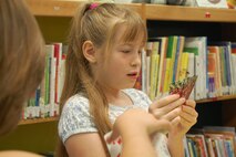 LAUGHLIN AIR FORCE BASE, Texas – Ashley Hall examines her cards while playing “Go Fish” with other children at the kid’s summer reading program at the Laughlin library July 6. The kid’s summer reading program meets every Tuesday through Aug. 3 and revolves around the theme “Voyage to Book Island”. During the program, the kids participate in several different activities and have a snack in addition to a book being read aloud to them. (U.S. Air Force Photo by Staff Sgt. Desiree Economides)