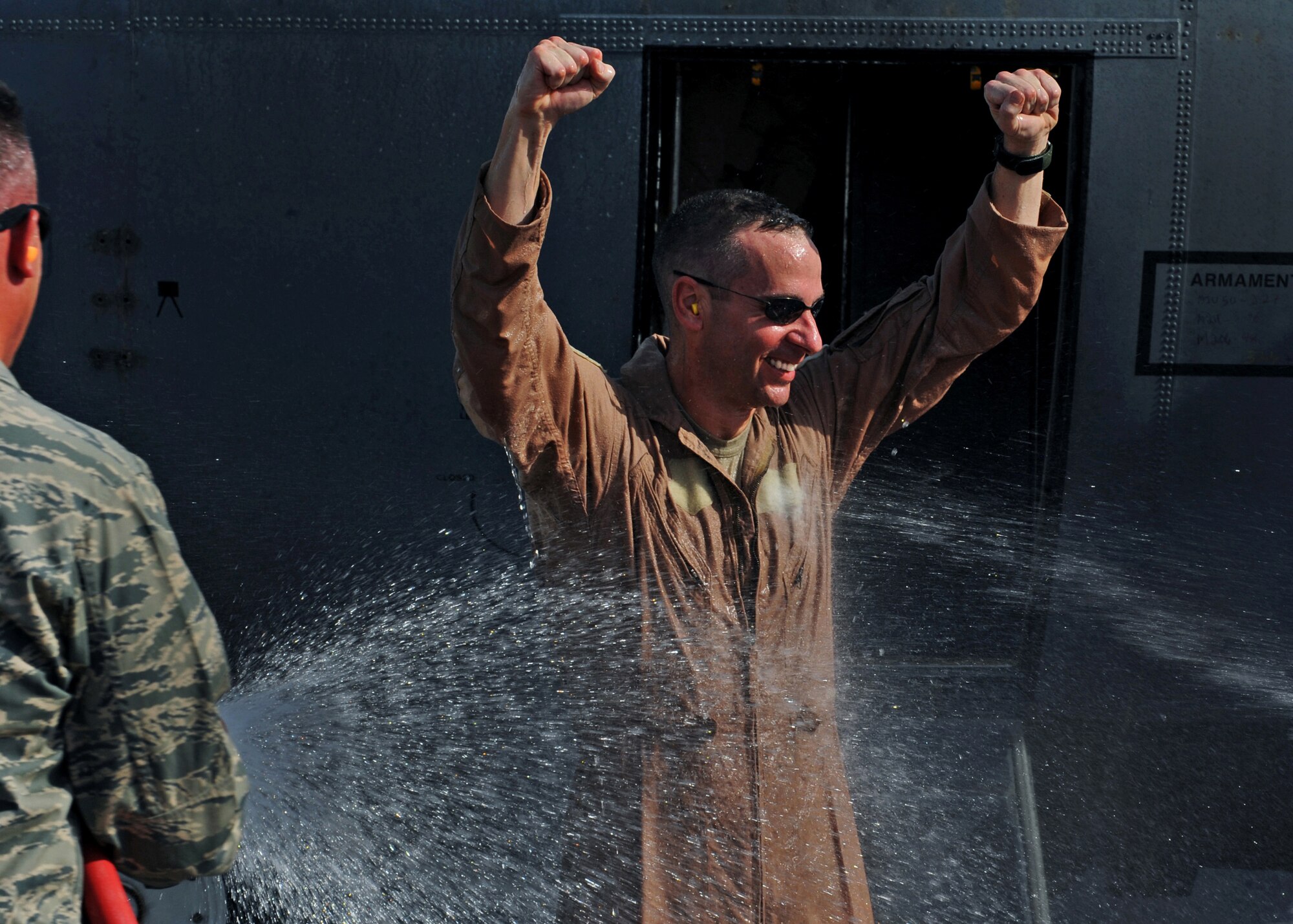 SOUTHWEST ASIA - Col. Mark Czelusta, outgoing commander of the 386th Expeditionary Operations Group, ducks to avoid a bubbly welcome from members of the 386th Air Expeditionary Wing, who doused him with non-alcoholic champagne after he completed his final flight here July 4, 2010. Colonel Czelusta said farewell as Col. Scott Brewer assumed command of the 386th EOG. (U.S. Air Force photo by Senior Airman Laura Turner)