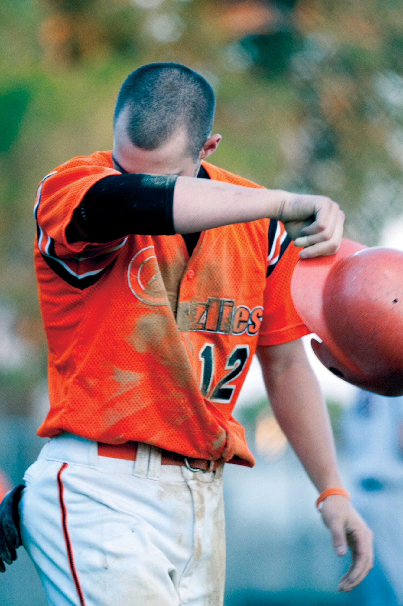 Mike Wido, No. 12, wipes his face after sliding head-first for a score during the Military Appreciation Night game June 24. (U.S. Air Force photo by Jeff Allred)