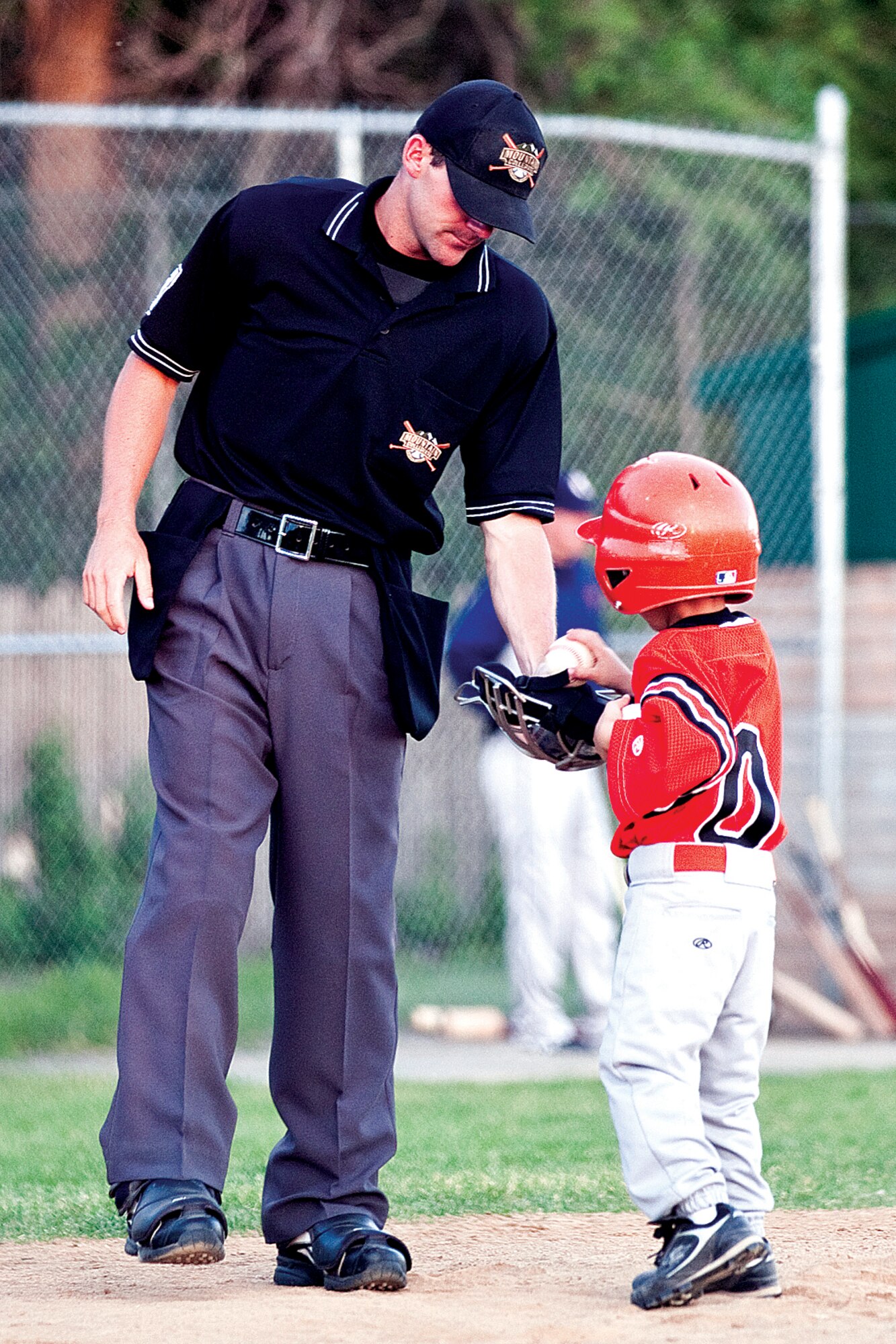 Cory Bombhoff, one of the Grizzlies bat-boys, gives the umpire a few game balls for the Military Appreciation Game on June 24. (U.S. Air Force photo by Jeff Allred)