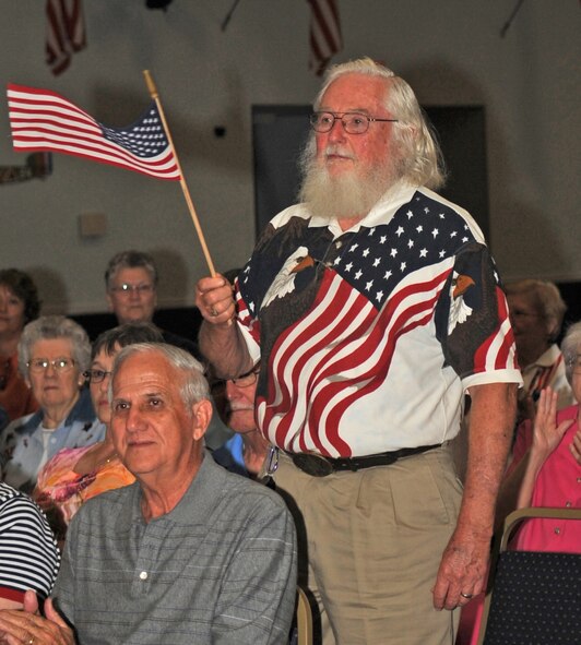 BARKSDALE AIR FORCE BASE, La. – Lee Clegg, stands up and waves the American flag during the United States Coast Guard’s song as the Shreveport Metropolitan Concert Band plays July 3 at Hoban Hall. Mr. Clegg stands up in remembrance of his son who served in the Coast Guard and lost his life in the line of duty 21 years ago. (U.S. Air Force photo by Senior Airman Alexandra M. Boutte) (RELEASED)