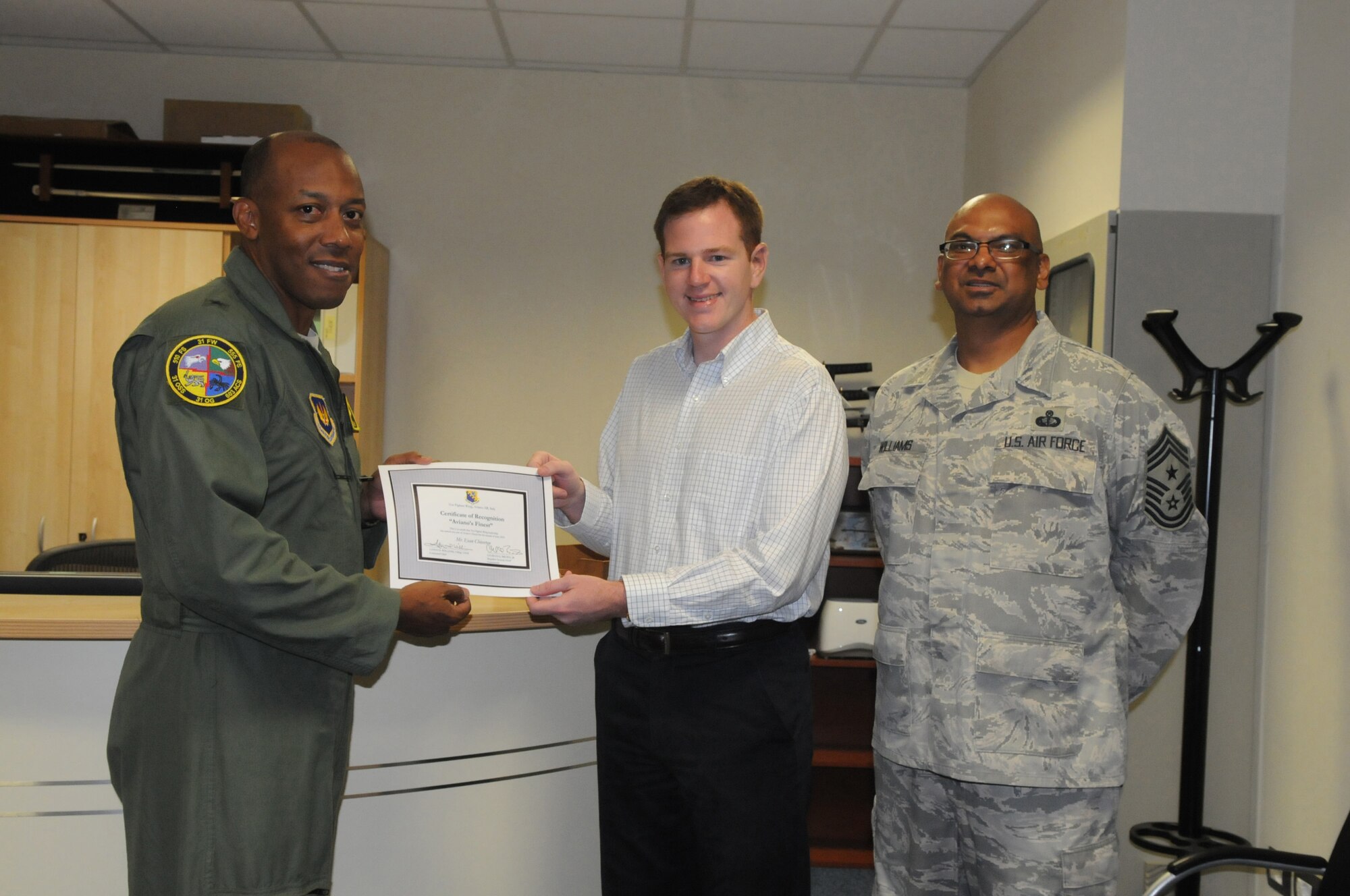 Brig. Gen. C.Q. Brown Jr., 31st Fighter Wing commander, along with Chief Master Sgt. Laten Williams, 31st FW command chief congratulates Mr. Evan Chiverton, 31st Maintenance Operations Squadron, on his selection as one of Aviano's Finest.(U.S. Air Force photo/Staff Sergeant Mercedeskimble L. Crossland)
