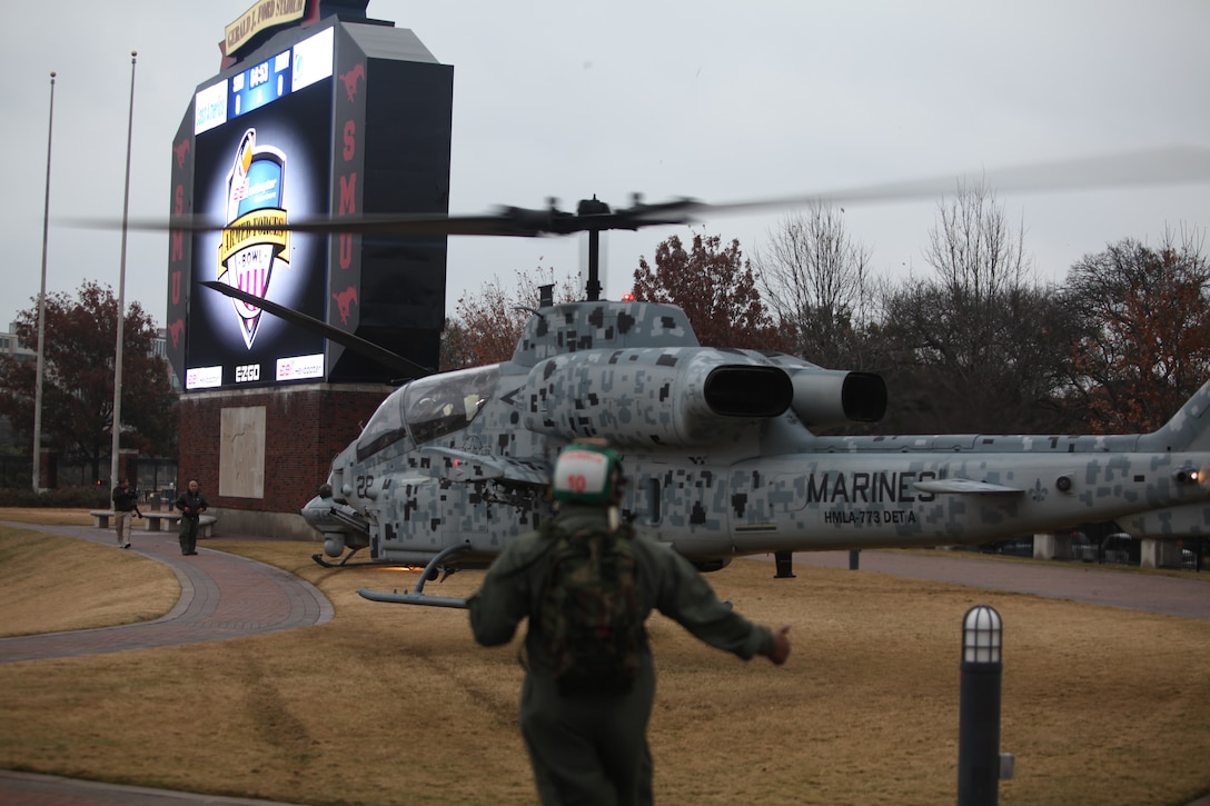 NAVAL AIR JOINT RESERVE BASE BELLE CHASSE, La.— Sgt. Nicholas Cohill, aviation noncommissioned officer, gives a thumbs up to signal “all clear,” as he helps in safely landing an AH-1 Cobra helicopter in the Southern Methodist University Stadium in Dallas for the Bell Helicopter Armed Forces Bowl, Dec.30. (Official Marine Corps photo by Lance Cpl. Fenton Reese)
