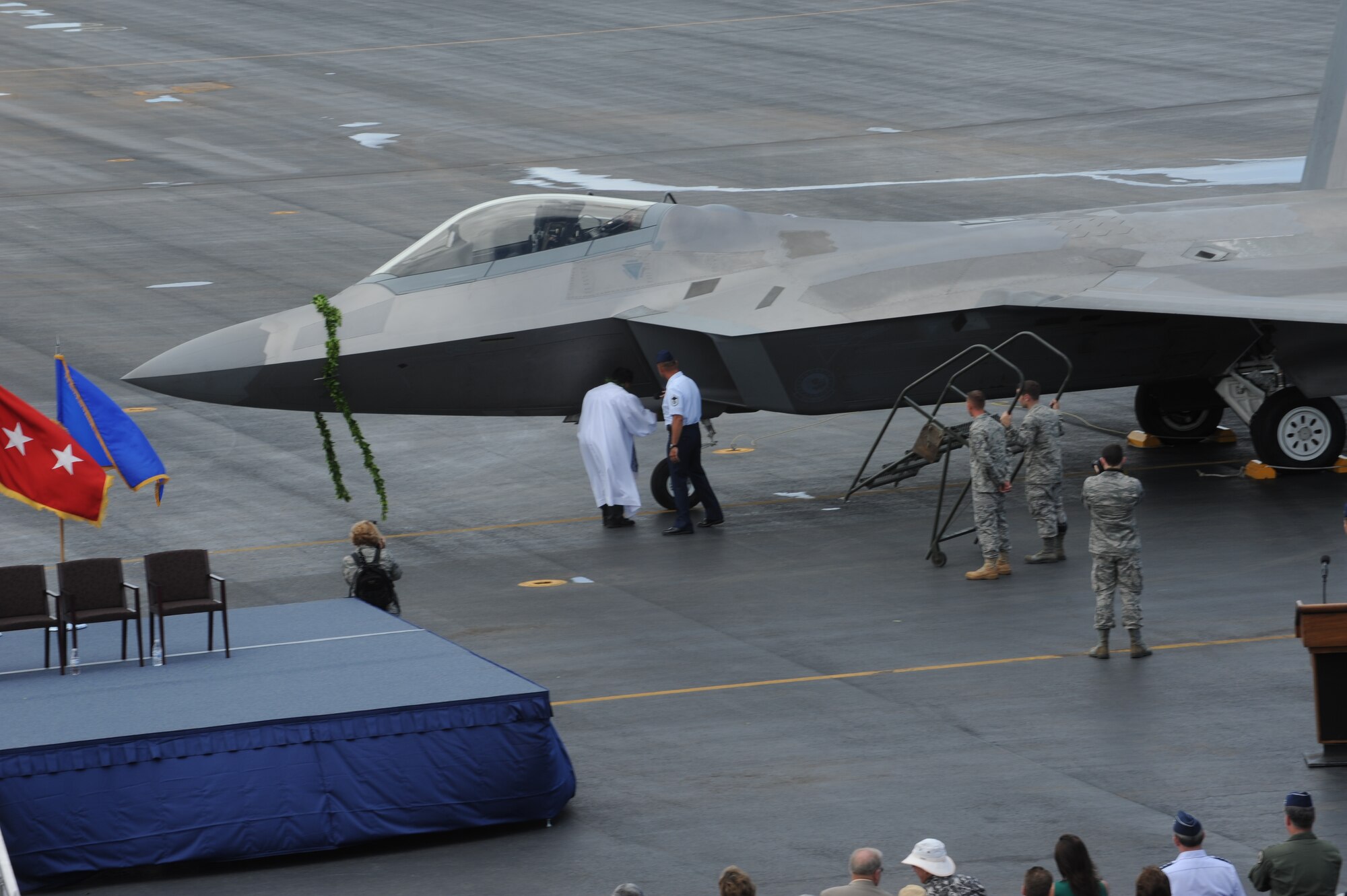 An F-22 Raptor is blessed by "Kahu" Kekoa Kordel, a local priest, during the F-22 Arrival Ceremony here, July 9. The F-22 Raptor is the Air Force's newest fighter aircraft. Its combination of stealth, supercruise, maneuverability, and integrated avionics, coupled with improved supportability, represents an exponential leap in warfighting capabilities. The ceremony marks the beginning of the partnership between the Hawaii Air National Guard and the active duty Air Force flying the “fifth generation” fighter at Hickam. The F-22 Raptors are assigned to the 199th Fighter Squadron, 154th Wing, Hawaii Air National Guard and the 19th Fighter Squadron, 15th Wing. (U.S. Air Force photo/Senior Airman Gustavo Gonzalez)