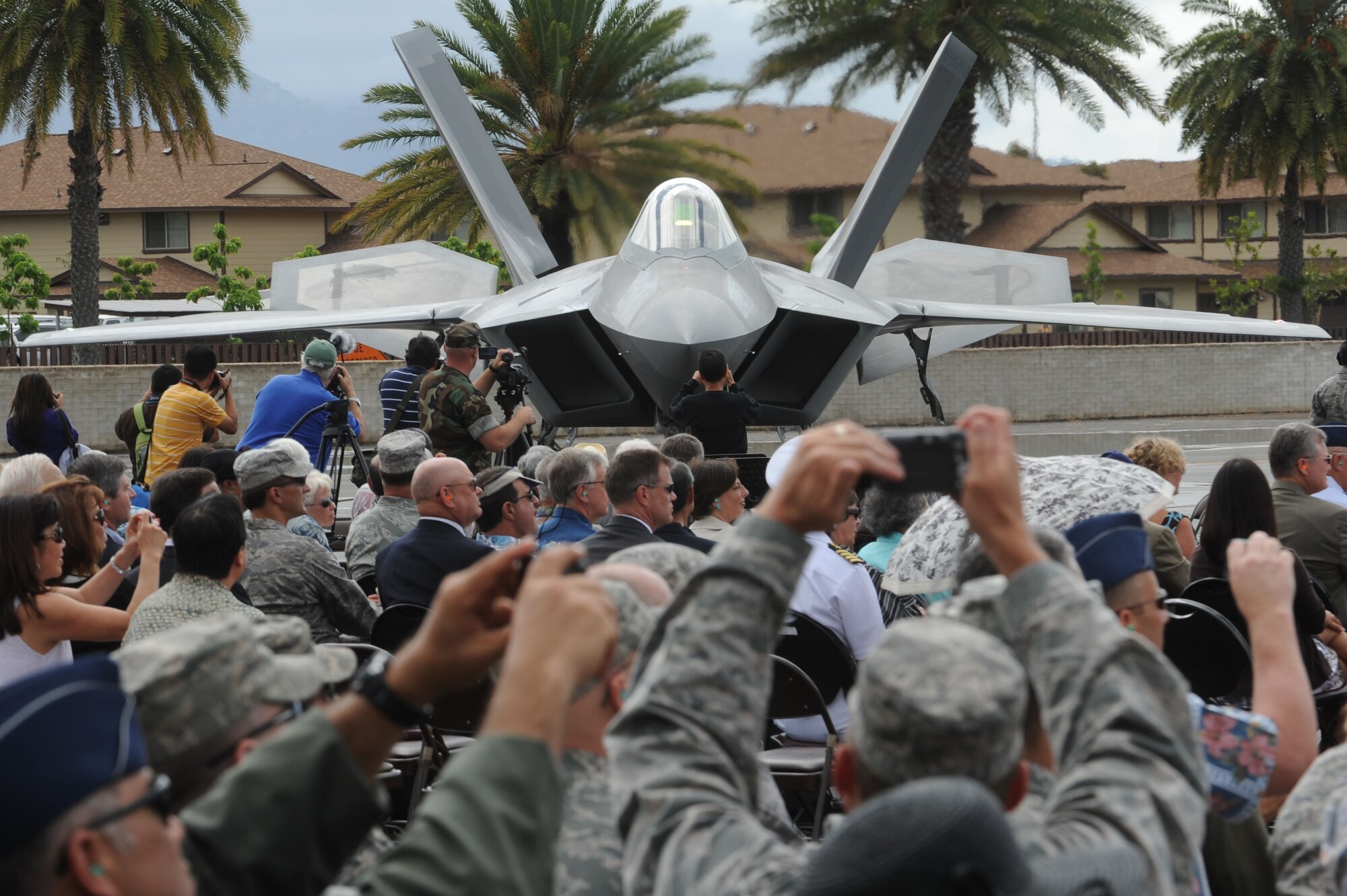 A crowd takes photos of an F-22 Raptor during the F-22 Arrival Ceremony here, July 9. The F-22 Raptor is the Air Force's newest fighter aircraft. Its combination of stealth, supercruise, maneuverability, and integrated avionics, coupled with improved supportability, represents an exponential leap in warfighting capabilities. The ceremony marks the beginning of the partnership between the Hawaii Air National Guard and the active duty Air Force flying the “fifth generation” fighter at Hickam. The F-22 Raptors are assigned to the 199th Fighter Squadron, 154th Wing, Hawaii Air National Guard and the 19th Fighter Squadron, 15th Wing. (U.S. Air Force photo/Senior Airman Gustavo Gonzalez)