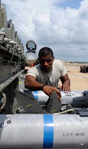 LANGLEY AIR FORCE BASE, Va.— Staff Sgt. Michael Holloway, 94th Aircraft Maintenance Unit weapons load crew member, loads fins onto an Air Intersect Missle 120 during the weapons load crew of the quarter competition July 9. Weapons load crews from the 94th, 71st, and 27th AMUs competed in the competition to show which load crew is the best.  (U.S. Air Force photo/ Senior Airman Dana Hill)