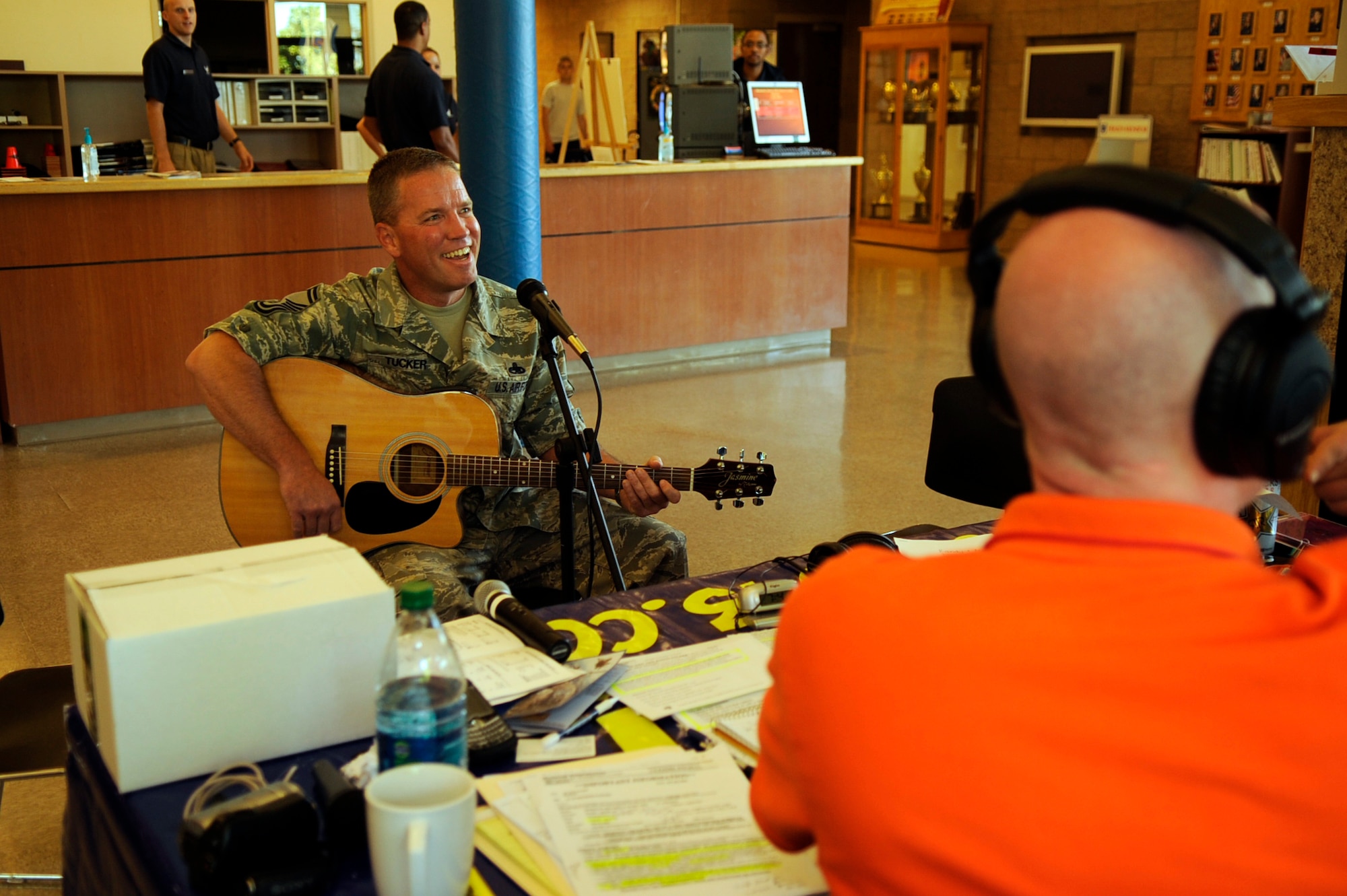 Senior Master Sgt. Douglas Tucker,366th Equipment Maintenance Squadron, performs for Randy and Alana of the WOW 104.3 Randy & Alana Show during a live radio broadcast from the fitness center here 1 July.  The talk show hosts interviewed a mixture of officers, enlisted Airmen and civilians of the base during their broadcast.  Topics focused on why our Airmen joined the Air Force, what they did in their current jobs, their deployment experiences and how life in the Air Force affects families both at home and deployed.  (U.S. Air Force photo by Airman 1st Class Angelina Drake)