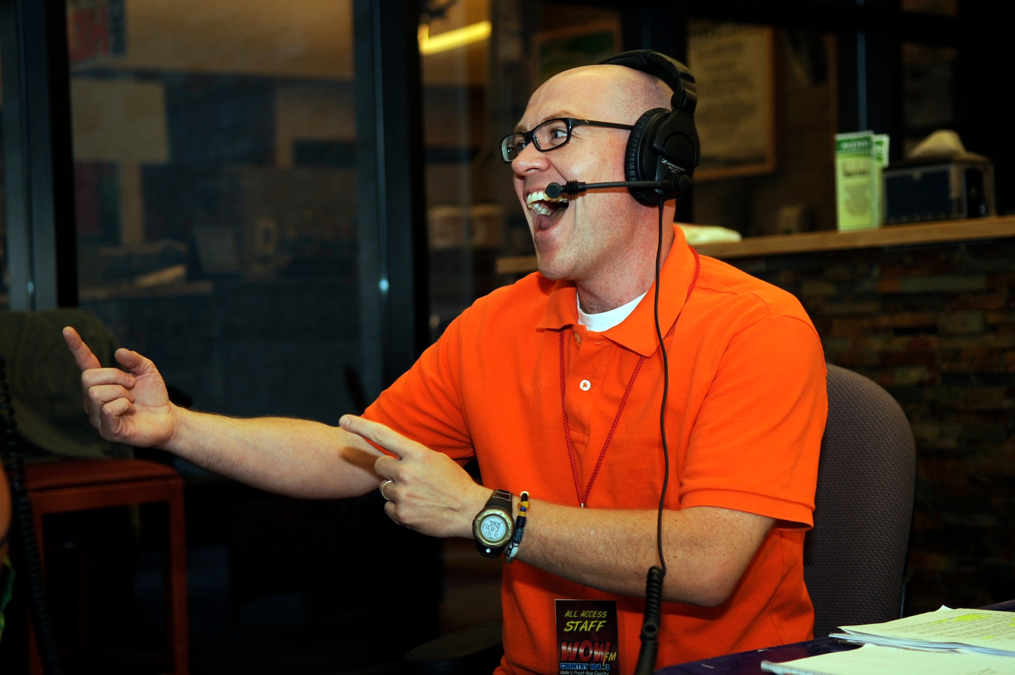 Randy Scott of the WOW 104.3 Randy & Alana Show remains animated even though his listeners are unable to see his face during the live radio broadcast from the fitness center here 1 July.  The talk show hosts interviewed a mixture of officers, enlisted Airmen and civilians of the base during their broadcast.  Topics focused on why our Airmen joined the Air Force, what they did in their current jobs, their deployment experiences and how life in the Air Force affects families both at home and deployed.  (U.S. Air Force photo by Airman 1st Class Angelina Drake)