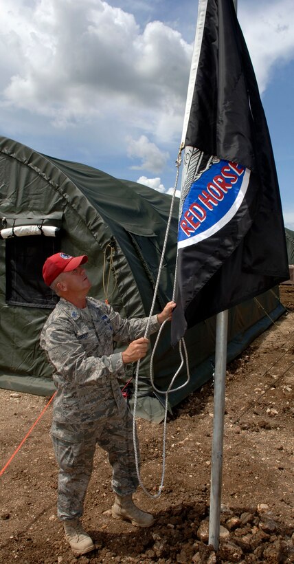 METETI, Panama -- Senior Chief Petty Officer Shawn Crosby raises the 820th Expeditionary RED HORSE Squadron flag over the base camp housing more 250 Airmen, Soldiers, Sailors and Marines taking part in New Horizons Panama 2010, a U.S. Southern Command sponsored humanitarian assistance mission. Crosby is the "Mayor" of tent city, responsible for for the day-to-day functioning of the camp, including the facilities, utilities, roads and people. (U.S. Air Force photo/Tech. Sgt. Eric Petosky)