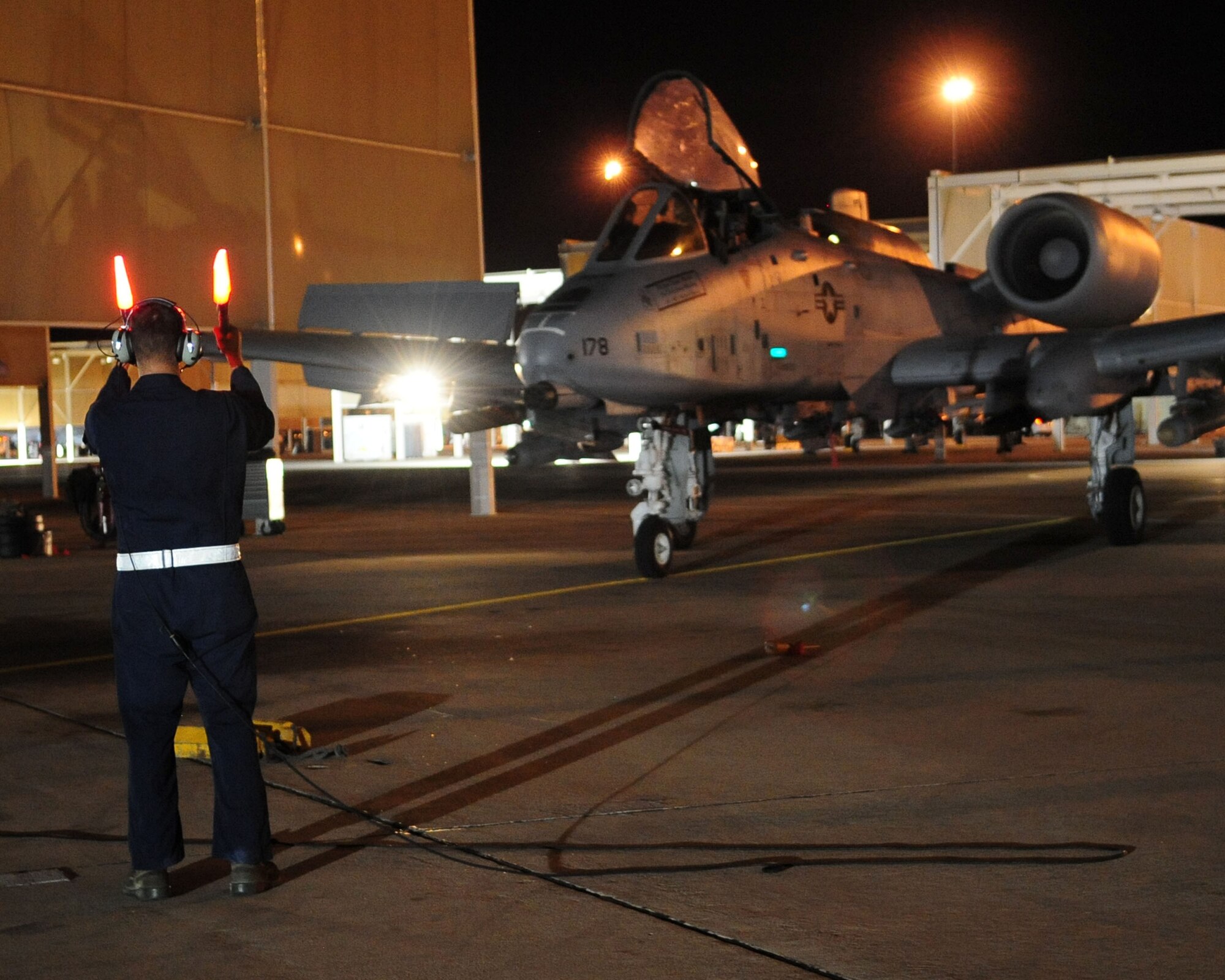 Airman 1st Class Jeff Gronemyer, an A-10C crew chief from the 355th Aircraft Maintenance Squadron, directs 1st Lt. Dan Griffin to his parking spot following his second night flight June 23. Lieutenant Griffin is a student in the A-10C Pilot Initial Qualification course. To learn more about his journey through the course, check out “Behind the Scenes: The Making of an A-10C Pilot” at www.dm.af.mil. (U.S. Air Force photo/Airman 1st Class Jerilyn Quintanilla)