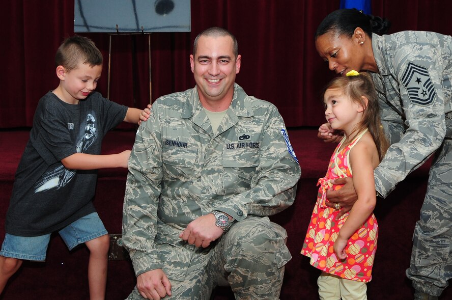 BARKSDALE AIR FORCE BASE, La. – Chief Master Sgt. Joe Ann Pace, 2d Bomb Wing command chief, shows Callie Jo, 4, the daughter of Staff Sgt. James Isenhour, 2d Maintenance Squadron, how to ‘tack on’ her father’s new technical sergeant rank while his son J.R., 6, tacks on the other stripe during the technical sergeant promotion party held at the Stripes Club July 6. (U.S. Air Force photo by Senior Airman Joanna M. Kresge)