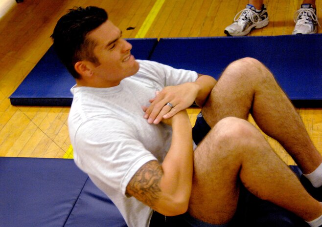 Staff Sgt. Joseph McTaggart completes the sit-up portion of his physical training test. Sergeant McTaggart was the fourth person at Nellis Air Force Base to complete the PT test after the new scoring and administrative changes took affect. (U.S. Air Force photo by Caitlin Fairchild)