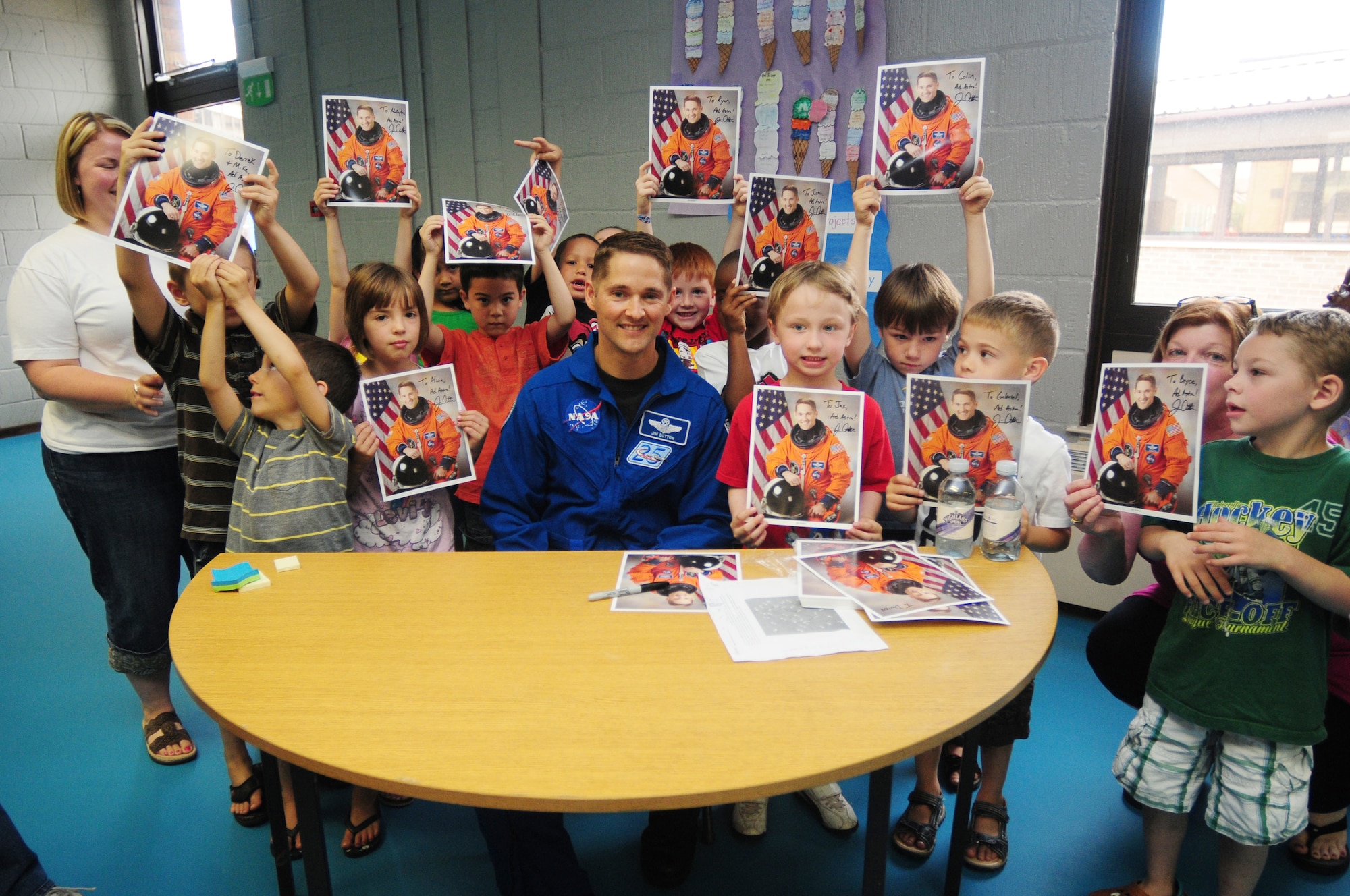 NASA astronaut Col. Jim Dutton, poses for a photo with Lakenheath Elementary School students July 9. Approximately 200 students turned out to see Colonel Dutton and have the opportunity to get an autograph. (U.S. Air Force photo/Airman 1st Class Lausanne Morgan)