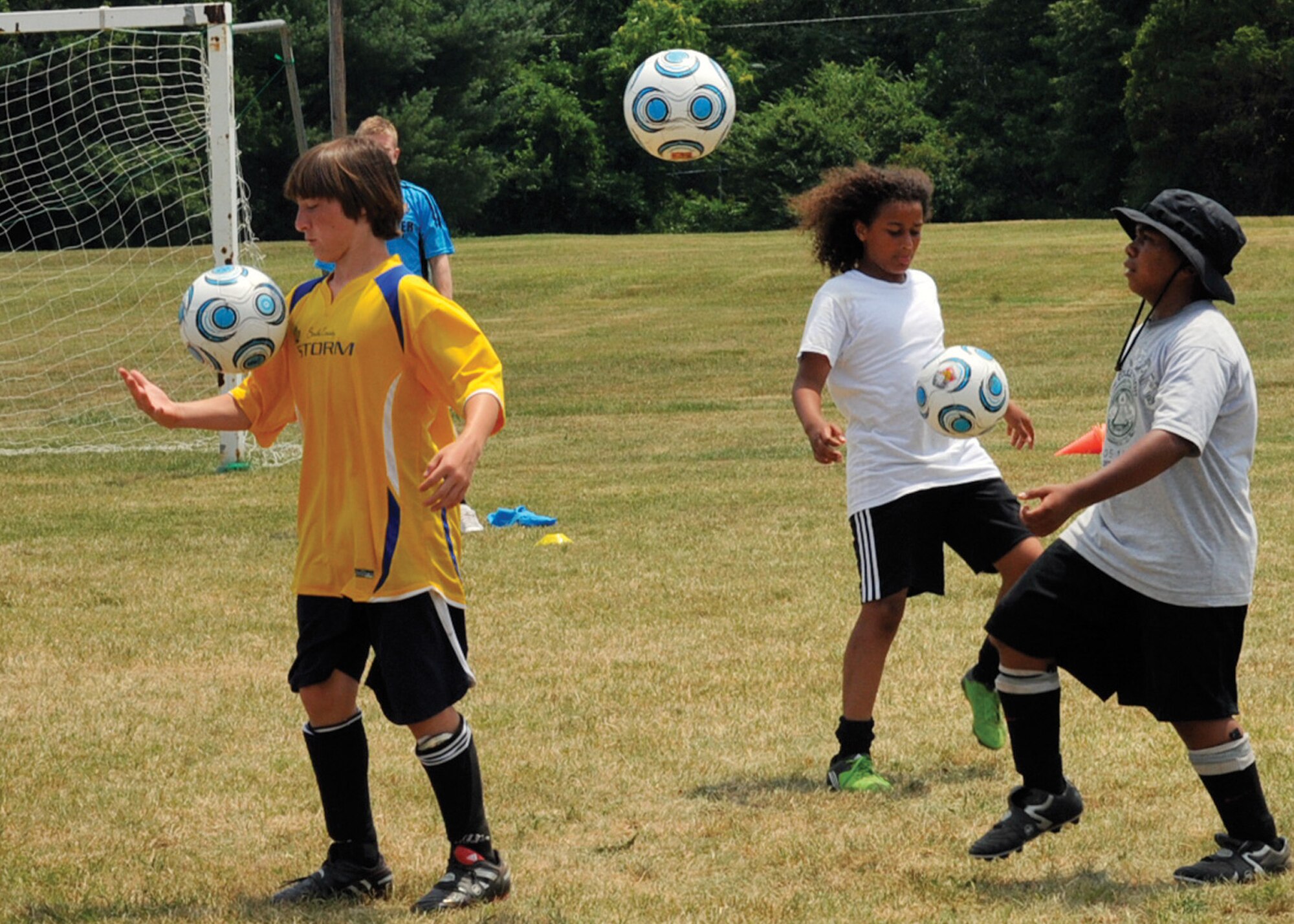 JOINT BASE ANDREWS, Md. -- Team Andrews Youth Center children perform a juggling drill June 25 at the Washington Field, near The Courses at Andrews. Sponsored by Challenger Sports, the week-long camp ran from June 21 through 25, and introduced the children to basic fundamentals of soccer including dribbling, passing, ball control and team camaraderie.  (U.S. Air Force photo by Bobby Jones)