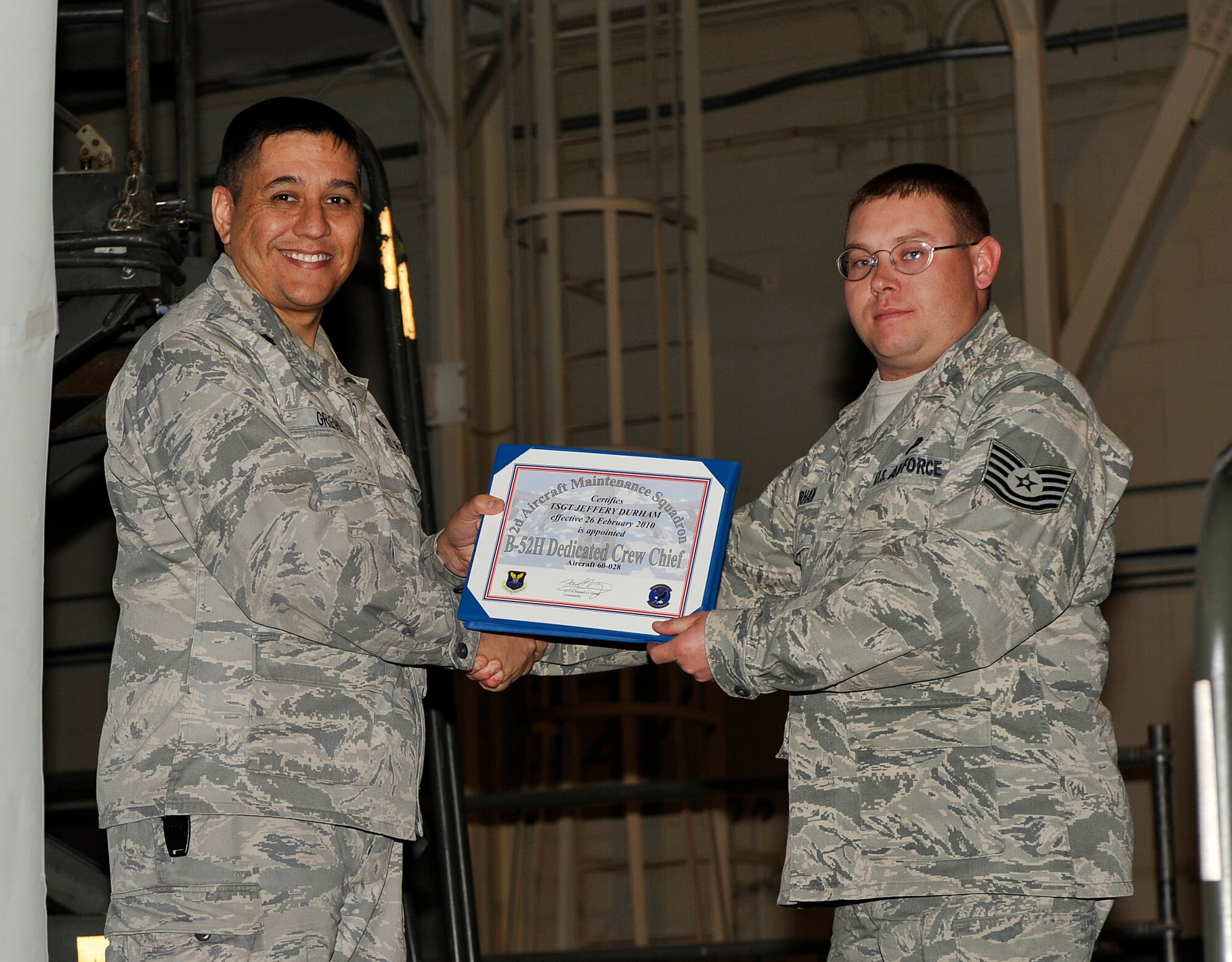 BARKSDALE AIR FORCE BASE, La. -- Lt. Col. Manuel Griego, 2d Aircraft Maintenance Squadron commander, presents Tech. Sgt. Jeffery Durham, 96th Bomb Squadron, with a certificate officially recognizing him as a dedicated crew chief.  The Dedicated Crew Chief Program is designed to appoint ownership of an aircraft to the most proficient, reliable maintainers. (U.S. Air Force photo by Senior Airman Chad Warren) (RELEASED)