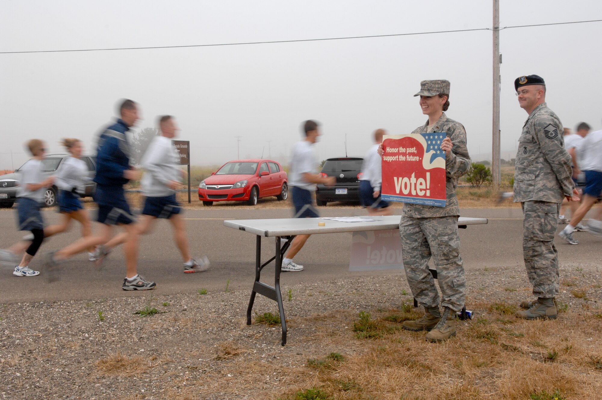 VANDENBERG AIR FORCE BASE, Calif. --  2nd Lt. Heather Flynn and Master Sgt. Michael Young, representatives from the Vandenberg Voting Committee, encourage runners to vote at the Fit-to-Fight run here Wednesday, June 30, 2010. The Vandenberg Voting Committee is dedicated to aiding registered voters and educating those who have yet to participate in the voting process. (U.S. Air Force photo/Staff Sgt. Levi Riendeau)