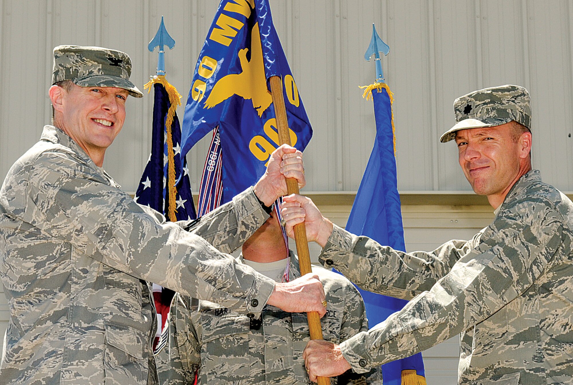 Col. Chuck Rogers assumes command of the 90th Civil Engineer Squadron from Lt. Col. Mike Geer on June 30. Col. John Boyle, Mission Support Group commander, presents Colonel Rogers with the 90th CES guideon. (U.S. Air Force photo by Gerald Teano)