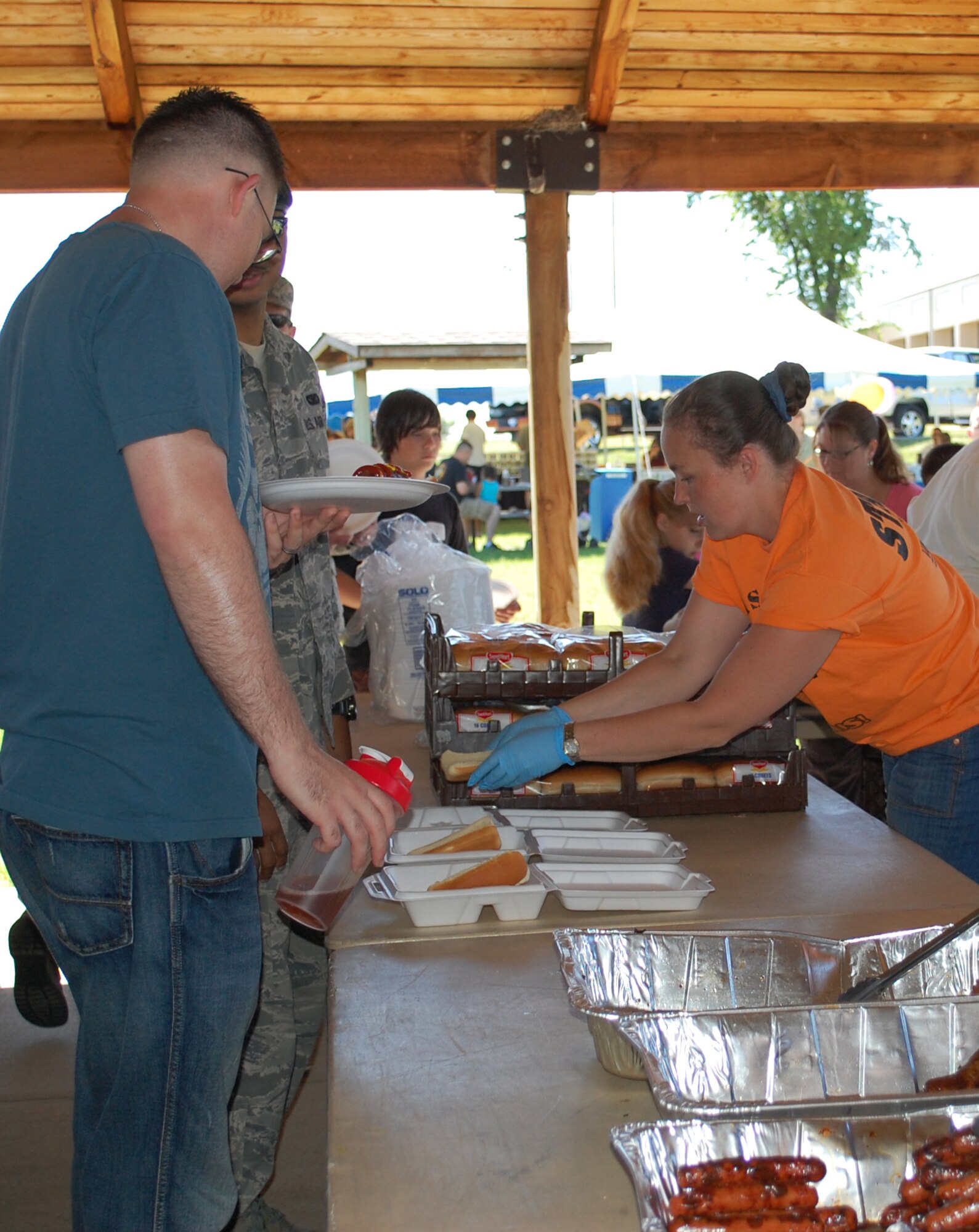 Rachel Kofoed helps some military members get their free lunch to go at the base picnic July 1. The event took place from 11 a.m. to 3 p.m. in the area in and around Sun Plaza Park. (U.S. Air Force photo/Valerie Mullett)