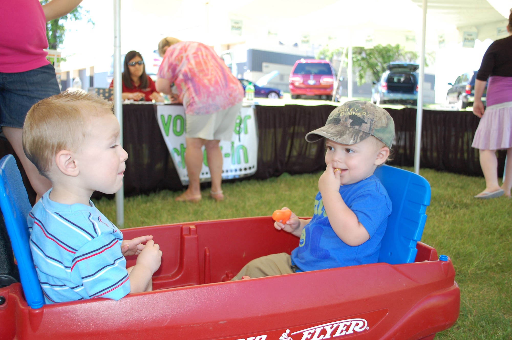 Little Warriors Eric (left) and Justin, both 2, enjoy some carmel corn provided courtesy of the Military Affairs Committee and the Chamber of Commerce. (U.S. Air Force photo/Valerie Mullett)