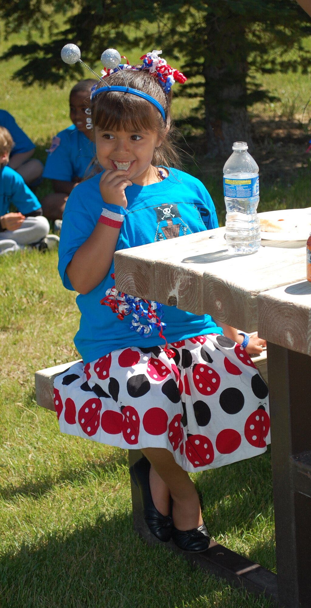 Little Warrior Adriana, 5, enjoys her lunch at the base picnic July 4. (U.S. Air Force photo/Valerie Mullett)