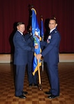 Col. Patrick Fogarty relinquishes command of the 802nd Mission Support Group by passing the guidon to Brig. Gen. Leonard Patrick, 502nd Air Base Wing commander, during a change of command ceremony July 7. (U.S. Air Force photo/Alan Boedeker)