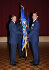 Col. Patrick Fogarty relinquishes command of the 802nd Mission Support Group by passing the guidon to Brig. Gen. Leonard Patrick, 502nd Air Base Wing commander, during a change of command ceremony July 7. (U.S. Air Force photo/Alan Boedeker)