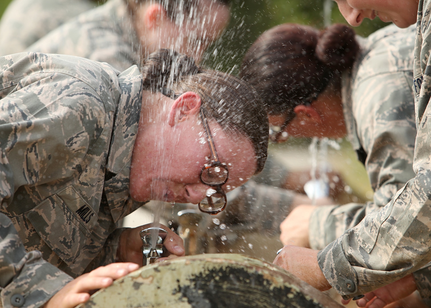 Trainees take a break from completeing the obstacle course to get a drink of water. In Air Force Basic Military Training, trainees learn the critical importance of discipline, teamwork and foundational knowledge needed to succeed as an Airman. (U.S. Air Force photo/Robbin Cresswell) 