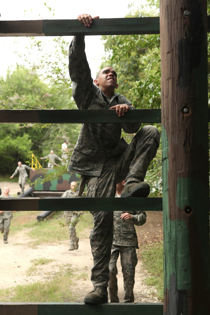 A trainee climbs an obstacle at the Air Force Basic Military Training obstacle course June 30. BMT mirrors the Air Expeditionary Force cycle -- trainees prepare to deploy, deploy to field exercises, and then reconstitute. (U.S. Air Force photo/Robbin Cresswell)