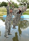 Air Force basic military trainees from the 320th Training Squadron cross a cold water pool at the obstacle course. The obstacle course is completed during the fourth week of BMT. (U.S. Air Force photo/Robbin Cresswell)