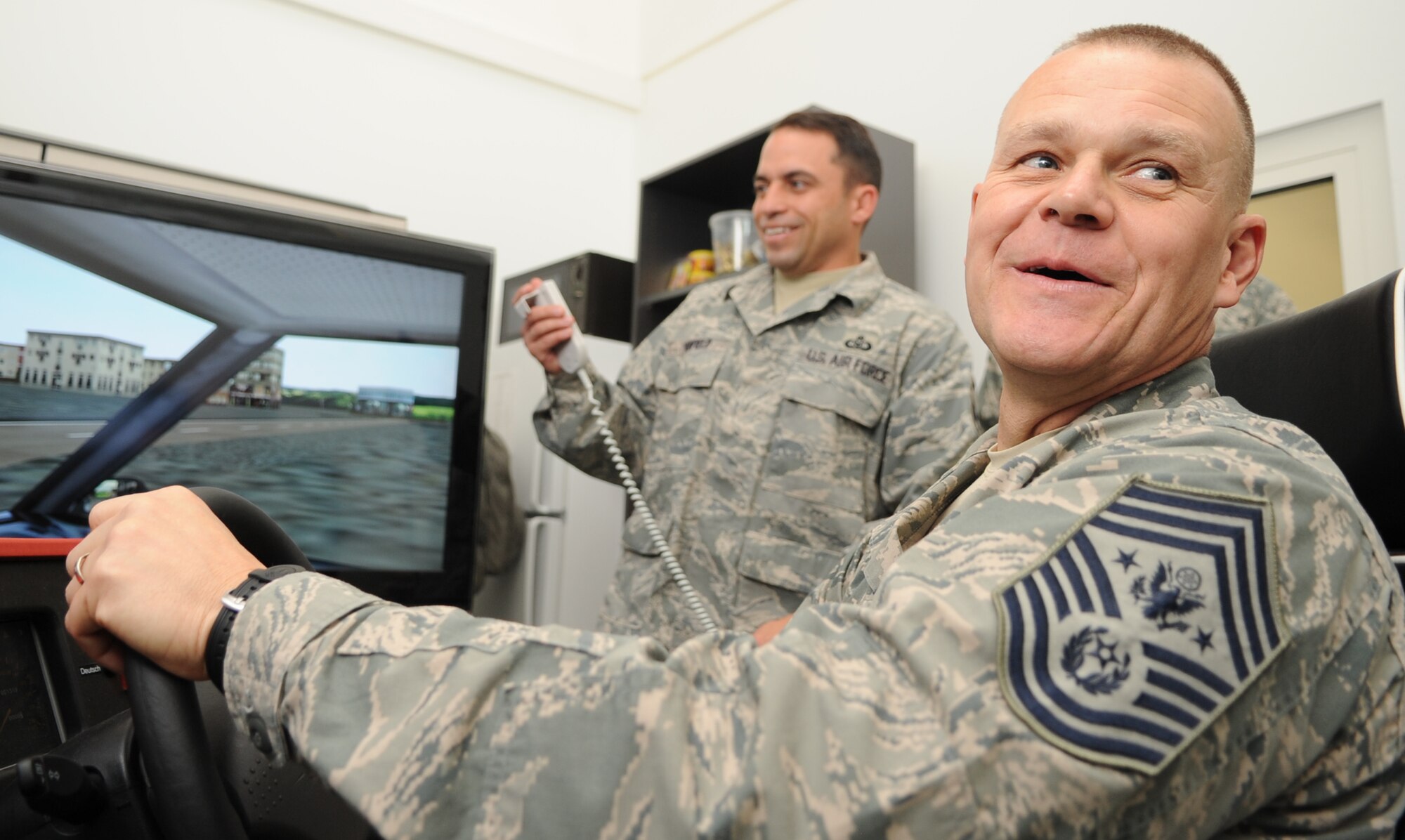 SPANGDAHLEM AIR BASE, Germany – Master Sgt. Joseph Winfield, 52nd Fighter Wing ground safety manager, helps Chief Master Sgt. of the Air Force James Roy test the Saber Driving Simulator while touring the base July 8. Chief Roy visited the 52nd Fighter Wing to see firsthand how U.S. Air Forces in Europe Airmen contribute to the fight while partnering with joint and coalition forces worldwide. Chief Roy is the 16th chief master sergeant appointed to the highest noncommissioned officer position. (U.S. Air Force photo/Airman 1st Class Nick Wilson)