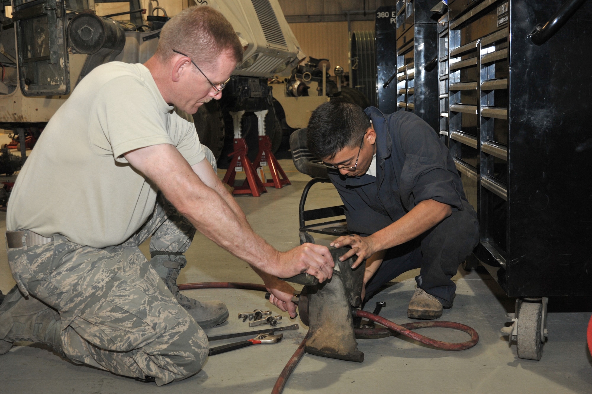 Master Sgt. Scott Listberger and Staff Sgt. Reed Nakamoto, 380th Expeditionary Logistics Readiness Squadron vehicle maintainers, work on a power steering pump bracket for a Humvee July 7 at an undisclosed location in Southwest Asia.  The maintainers are responsible for repairs and maintenance for over 230 vehicles. Sergeant Listberger is deployed from the Minnesota Air National Guard and Sergeant Nakamoto is deployed from the Hawaii Air National Guard. (U.S. Air Force photo/ Tech. Sgt. April Wickes)