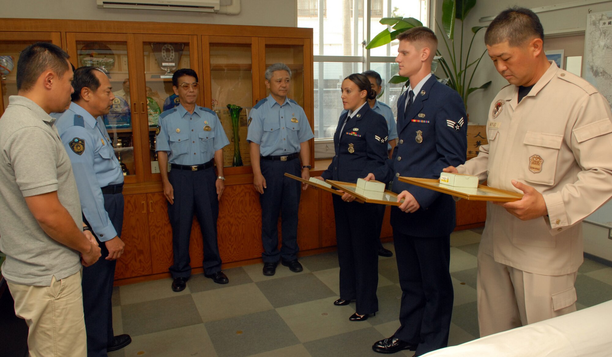 Kadena 18th Security Forces members Airman First Class Marlyn Pereyra, Senior Airman Jeremy Hammer and Officer Hiroyuki Miyagi stand with members of the Okinawa Police Station after receiving letters of recognition for their part in detaining a local citizen who was driving under the influence of alcohol. (U.S. Air Force photo / Junko Kinjo)
