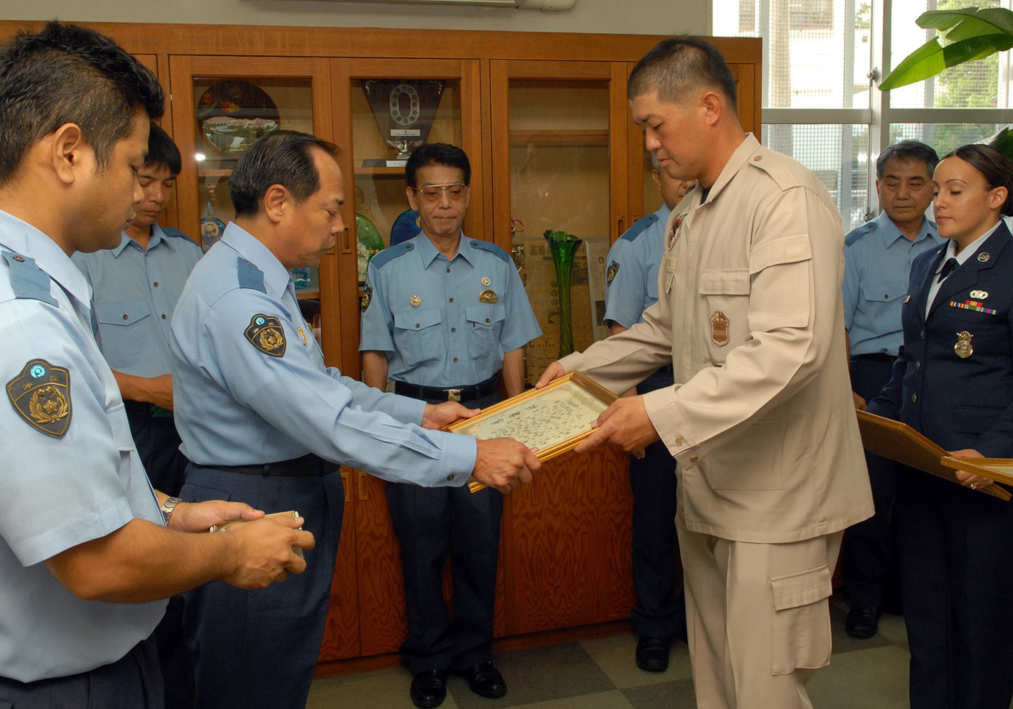 Security forces officer Hiroyuki Miyagi receives his letter of recognition from Okinawa Police senior superintendent Seiei Ishiara during a ceremony at the Okinawa Police Station. (U.S. Air Force photo / Junko Kinjo)
