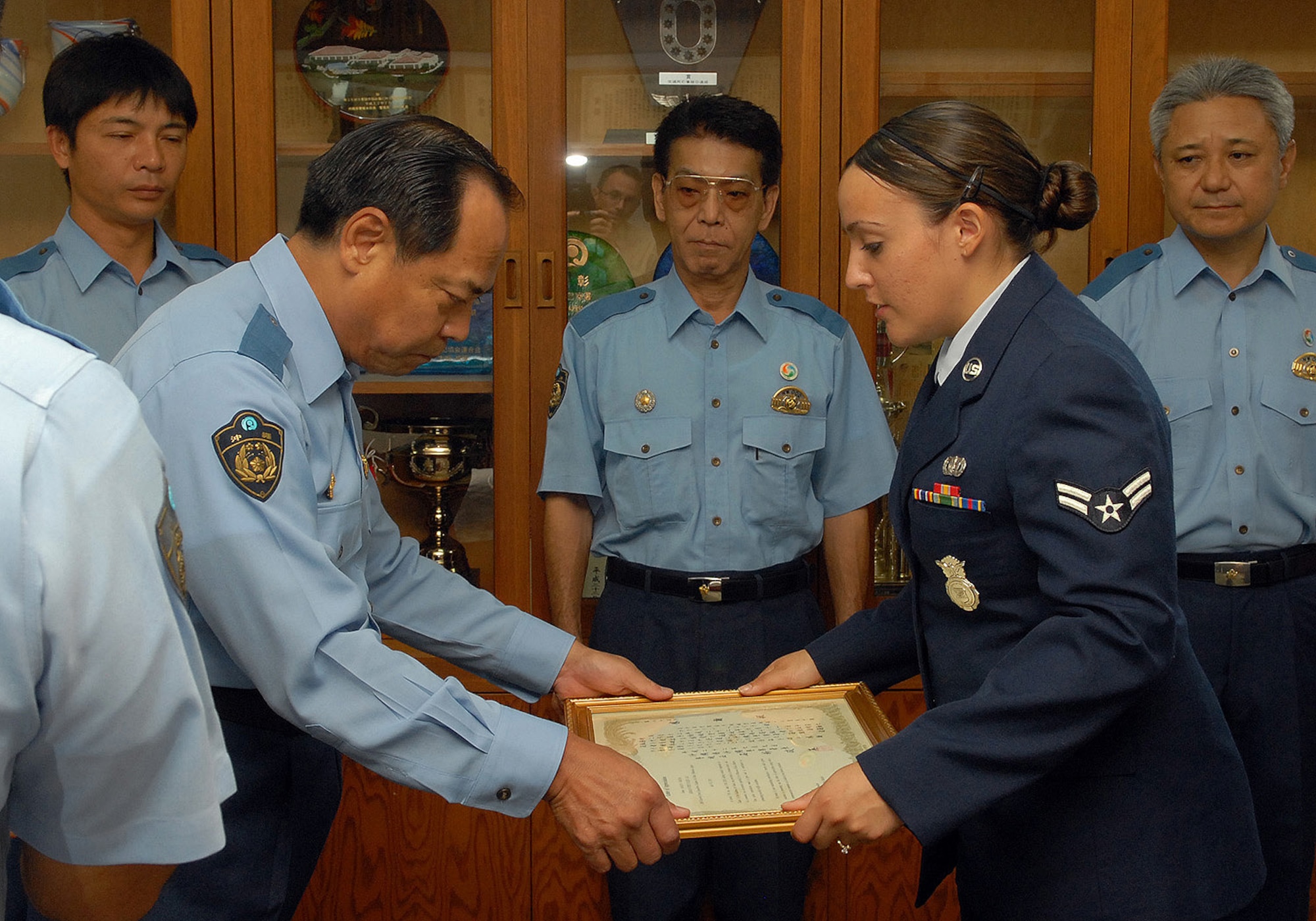 Airman First Class Marlyn Pereyra receives her letter of recognition from Okinawa Police senior superintendent Seiei Ishiara during a ceremony at the Okinawa Police Station. (U.S. Air Force photo / Junko Kinjo)
