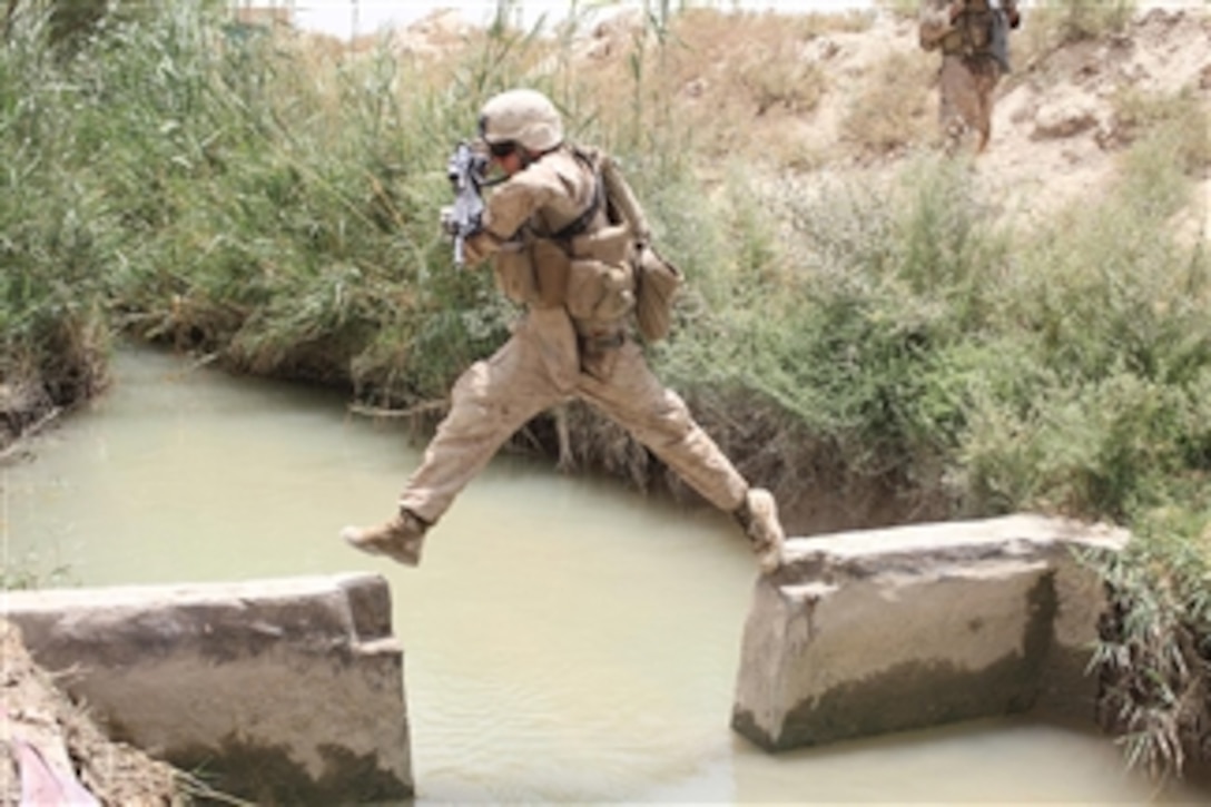 A U.S. Marine with Weapons Company, 3rd Battalion, 1st Marine Regiment, Regimental Combat Team 7 patrols back to Patrol Base Gorgak after a controlled detonation of an improvised explosive device in Garmsir, Afghanistan, on July 5, 2010.  When found improvised explosive devices are destroyed by a small charge placed on top of them.  