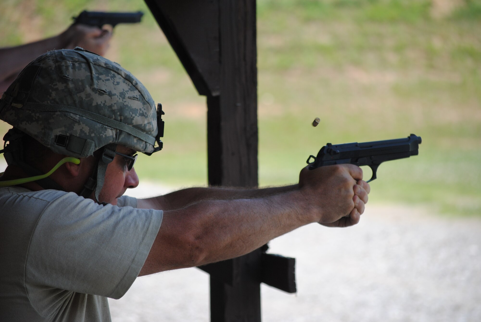 A competitor in the 2010 Tennessee National Guard shooting competition takes a kneeling firing position and fires an M-9 pistol at his target.