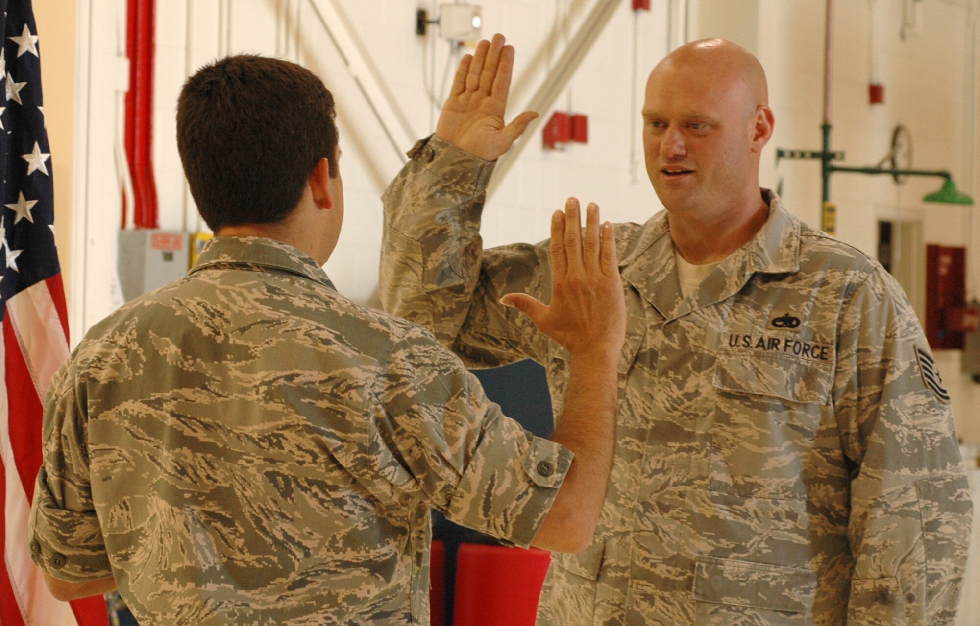 Tech. Sgt. Kennon Colvin (right) takes the oath of enlistment July 1 from Lt. Col. Carlos Ortiz, 52nd Airlift Squadron commander, at Peterson Air Force Base, Colo. Sergeant Colvin, a C-130 crew chief assigned to the 52nd AS, re-enlisted in front of other members of the squadron. Afterwards, Girls of the West ladies Jessica Greene and Dayna Jenkins surprised him with a group photo. Both Miss Greene, the Girl of the West, and her aide, Miss Jenkins, received an up-close look at the 302nd Airlift Wing's primary mission of tactical airlift and airdrop and experienced the re-enlistment ceremony for the 52nd AS member. The 52nd AS is an Active Duty C-130 unit associated with the 302nd AW. The 302nd AW is an AF Reserve-assigned unit also charged with mission of aerial firefighting using the Modular Airborne Firefighting System. For more information on the Girls of the West, visit www.coloradospringsrodeo.com. (U.S. Air Force photo/Staff Sgt. Stephen J. Collier)
