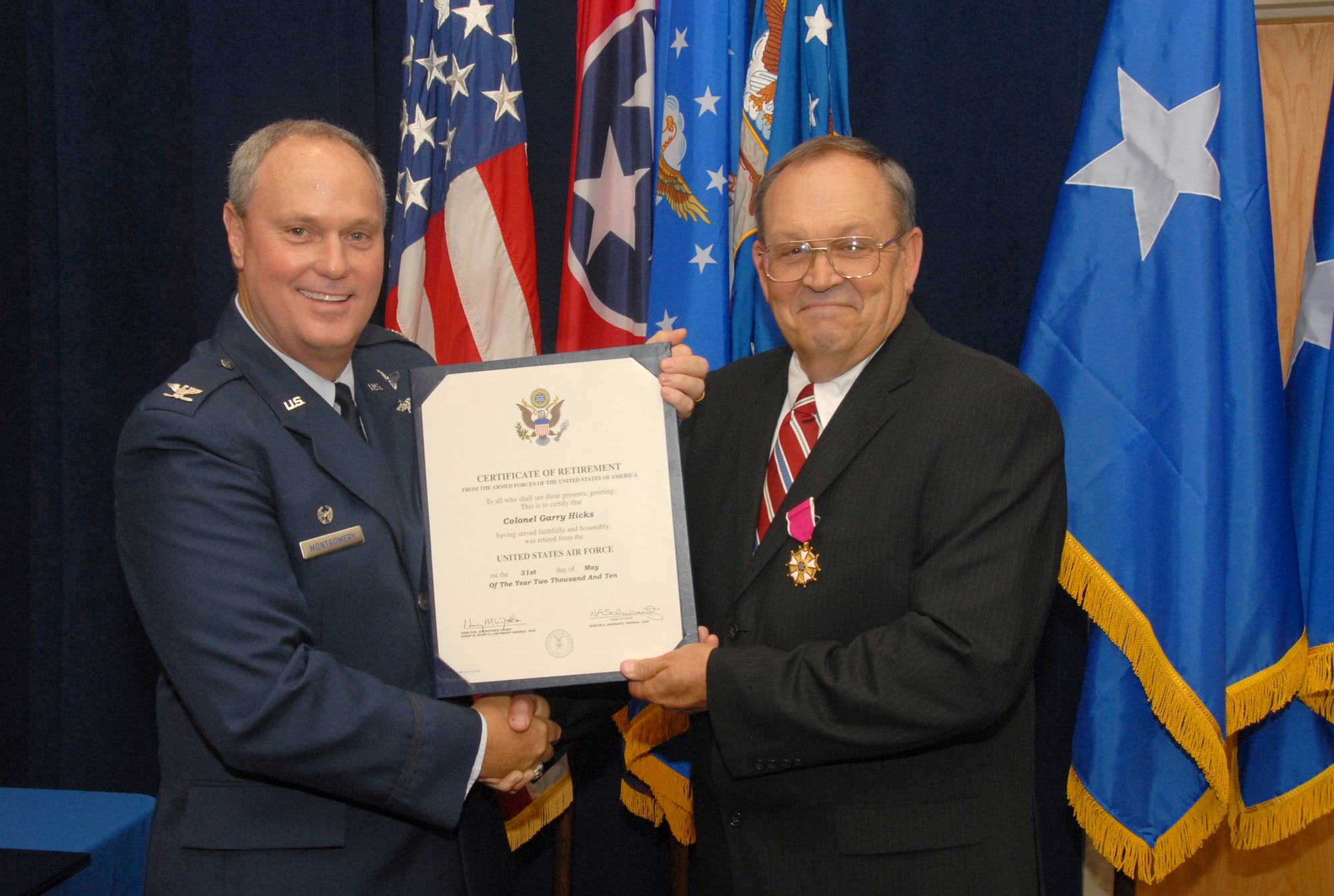 Col Gary Hicks recieves his certificate of retirement from Colonel Harry  Montgomery during his retirement ceremony.