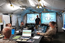 Inside the Combat Operations Center tent of combined, multinational exercise Partnership of the Amercias 2010 (POA-10) and Southern Exchange 2010 (SE-10), Dustin Ortegon of QinetiQ North America, teaches a class to a group of Marines regarding the capabilities of the Operations Trailer, or OT, which combines cutting-edge technology with rapid deployment capability. The two-wheeled trailer carries all the necessary equipment to setup and establish a high-tech Combat Operations Center including: essential servers, routers and encryption systems that can reach back to standard military radios or to the internet via satellite.