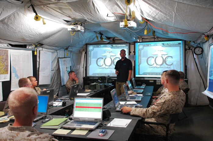 Inside the Combat Operations Center tent of combined, multinational exercise Partnership of the Amercias 2010 (POA-10) and Southern Exchange 2010 (SE-10), Dustin Ortegon of QinetiQ North America, teaches a class to a group of Marines regarding the capabilities of the Operations Trailer, or OT, which combines cutting-edge technology with rapid deployment capability. The two-wheeled trailer carries all the necessary equipment to setup and establish a high-tech Combat Operations Center including: essential servers, routers and encryption systems that can reach back to standard military radios or to the internet via satellite.