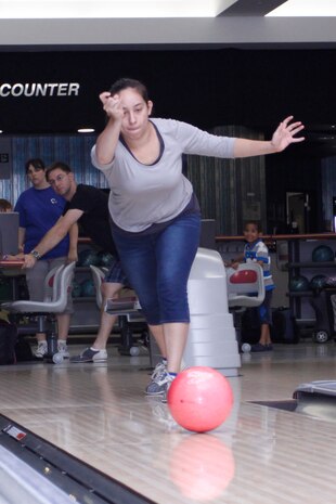 Mel Mumme, bowler for the Nuts and Cherries team, rolls the ball down the lane as she takes a turn to knock down some pins during the Intramural Bowling Tournament at the Strike Zone here July 10.