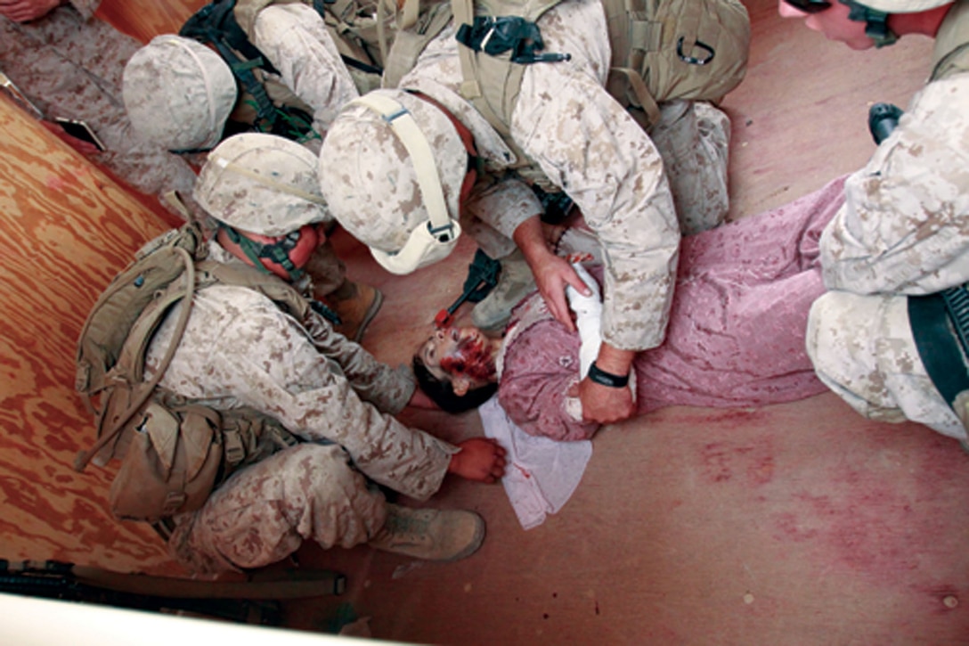 Marines with Company E, 2nd Battalion, 1st Marine Regiment, provide simulated medical care to an Afghan role player during a casualty-assessment training exercise Sunday at MCAGCC Twentynine Palms. Following a simulated improvised explosive device attack during a routine training patrol, members of CLB-3’s female engagement team and 2/1 were assessed on their ability to provide on-site medical care to role players.