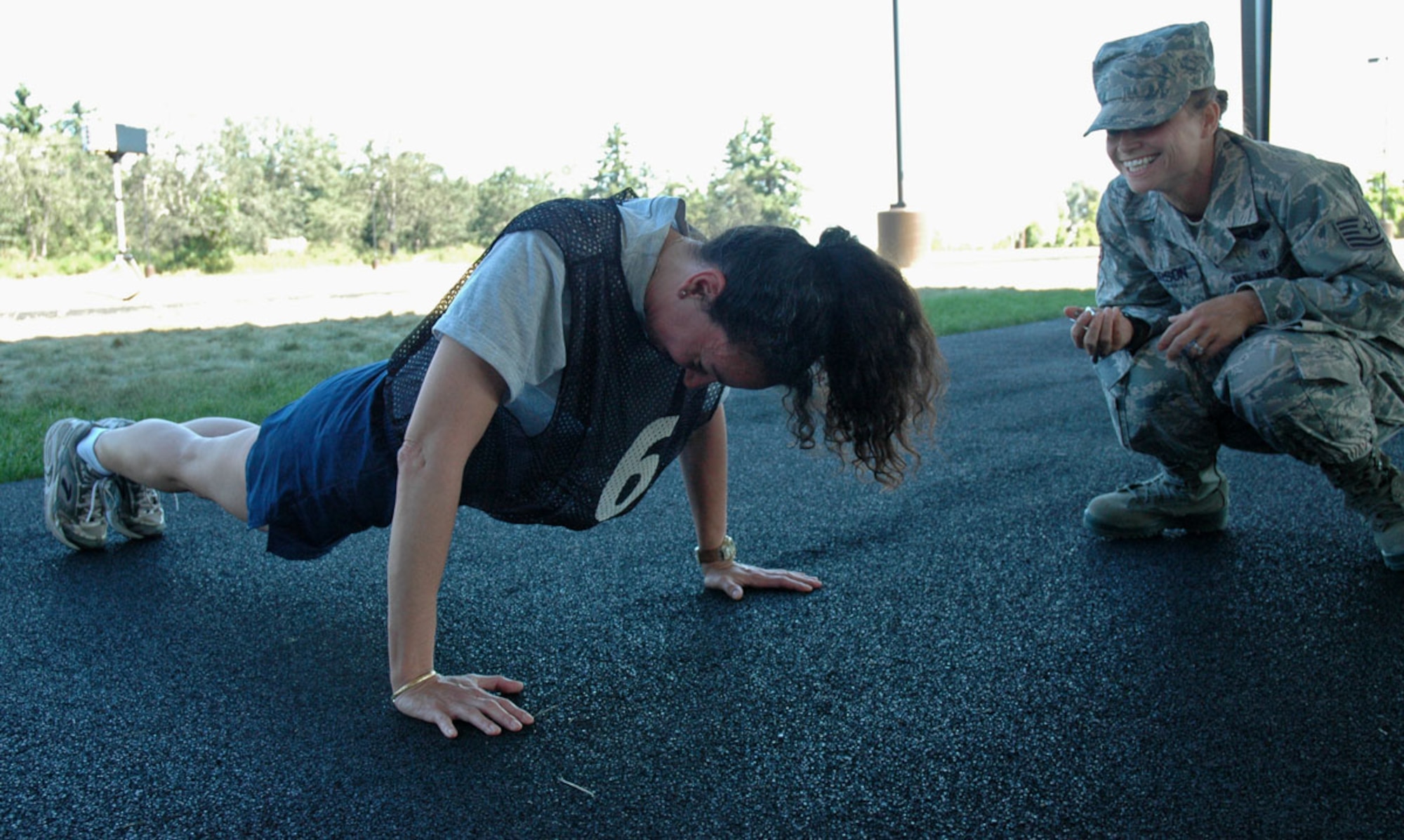JOINT BASE LEWIS-MCCHORD, Wash. -- Maj. Esther Aubert, 446th Aeromedical Evacuation Squadron, cranks out push ups over the watchful eye of her fitness monitor, Tech Sgt. Jill Peterson, 446th AES, during a fitness assessment here July 10, 2010.  The new Air Force fitness program took effect July 1. The program will hold Airmen to more rigourous physical fitness standards in an effort to improve overall health and readiness. (U.S. Air Force photo/Staff Sgt. Grant Saylor)