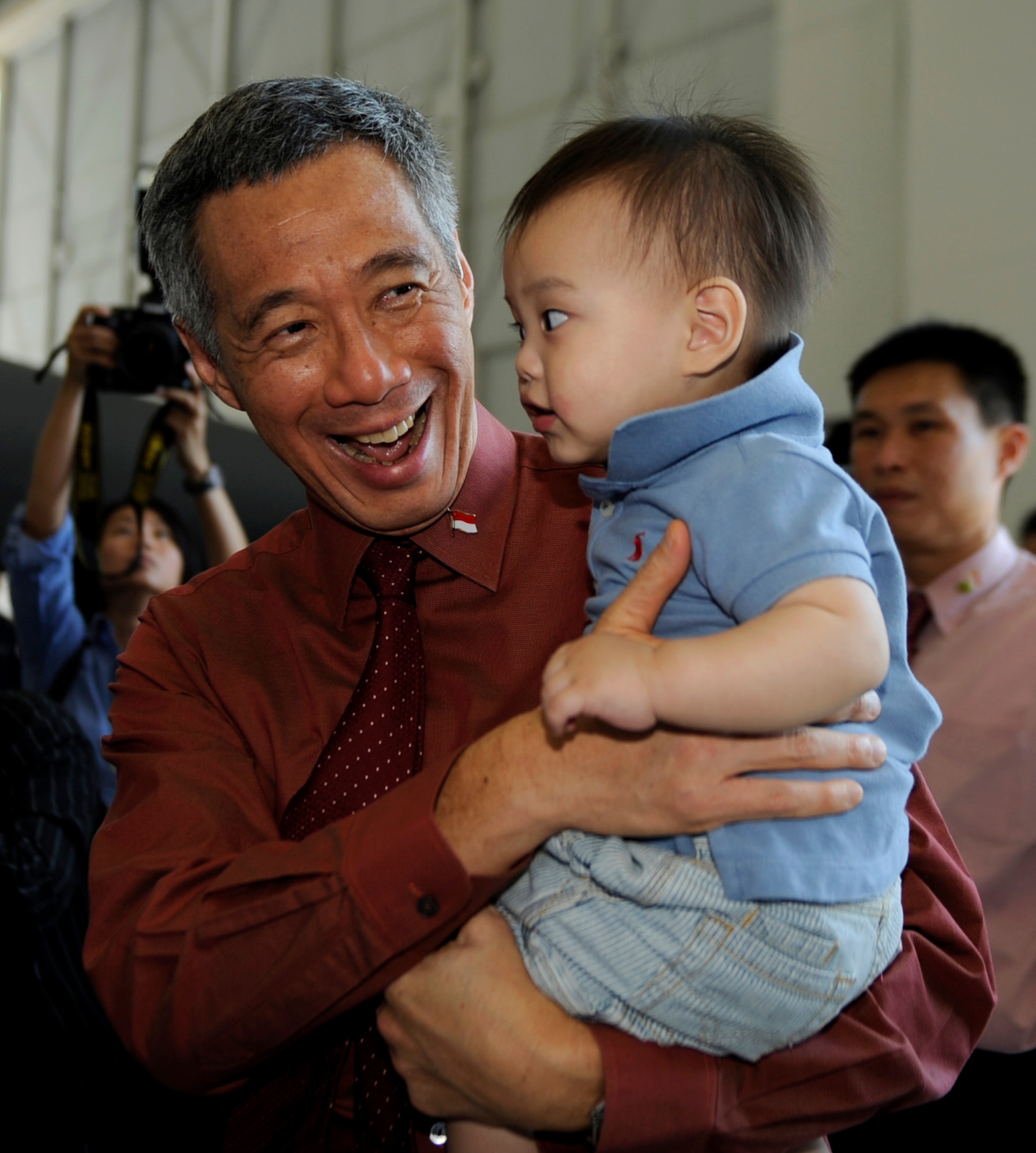 MOUNTAIN HOME AIR FORCE BASE, Idaho – Mr. Lee Hsien Loong, Republic of Singapore prime minister reacts as he holds one year old Goh Rei Jei July 11 during a base visit. Prime Minister Lee visited the base in order to tour the 428th Fighter Squadron, a squadron operated by members of the Republic of Singapore Air Force and the U.S. Air Force, and to meet with RSAF Airmen and their families. Prime Minister Lee toured base facilities, received mission briefings and discussed the importance of the partnership between the U.S. and Singapore.(U.S. Air Force photo by Senior Airman Renishia Richardson)