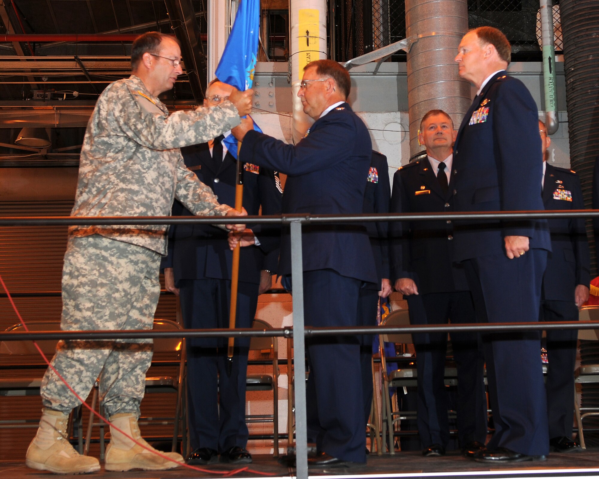 Major General Brian Tarbet, Adjutant General for the Utah National Guard, passes the flag to Colonel Wayne Lee, who assumed command as the Assistant Adjutant General of the Utah Air National Guard in a ceremony on July 10, 2010, at the 151st Air Refueling Wing, Salt Lake City. (U.S. Air Force photo by MSgt Gary J. Rihn) 	