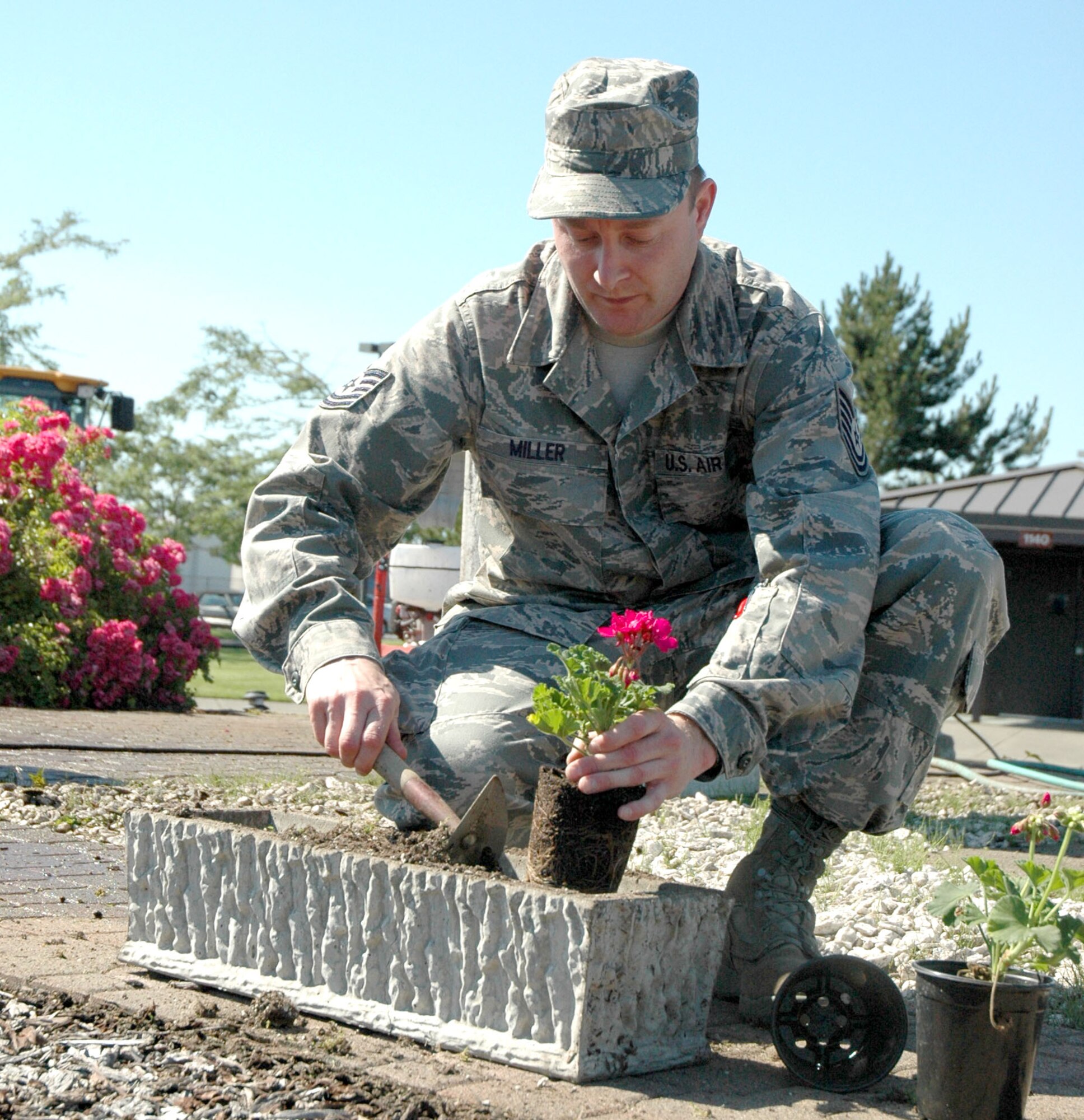JOINT BASE LEWIS-MCCHORD, Wash. - Tech. Sgt. Brian Miller, hydraulics specialist with 446th Aircraft Maintenance Squadron, carefully places new flowers into a flower bed, during the 446th AMXS' memorial site cleanup here, July 10. Sergeant Miller and other 446th AMXS aircraft maintainers took part in the beautification effort, to honor the 13 Airmen who died after their 
C-141 crashed over Montana in Nov. 1992. All crew members were active duty from McChord Field. (U.S. Air Force Photo/Staff Sgt. Nicole Celestine)