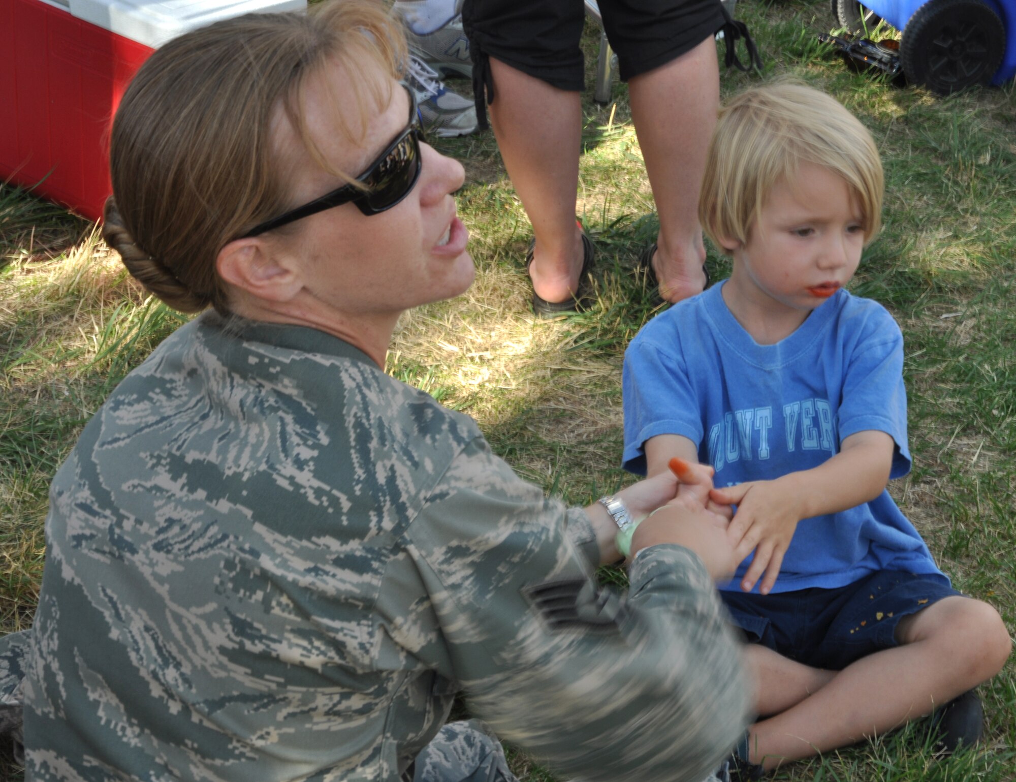 Staff Sgt. Denise Flory, an Air Force Reservist with the 302nd Maintenance Group, helps her son Luke, 4, with his barbecue dinner July 10 during a 302nd MXG outing at Security Service Field in Colorado Springs, Colo. The C-130 Hercules maintainers, assigned to the AF Reserve's 302nd Airlift Wing at nearby Peterson Air Force Base, worked with the city's Sky Sox minor league baseball team to re-enlist five AF Reservists and one Active Duty Airmen in front of an estimated 3,000-person crowd.  (U.S. Air Force photo/Staff Sgt. Stephen J. Collier)